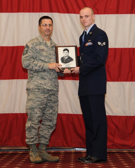 Senior Airman Trevor Szewczak, 608th Air and Space Operations Center, receives the John Levitow Award from Chief Master Sgt. Richard Young, 307th Maintenance Squadron, during the Airman Leadership School class 14-2 graduation on Barksdale Air Force Base, La., Feb. 13, 2014. (U.S. Air Force photo/Senior Airman Joseph A. Pagán Jr.)