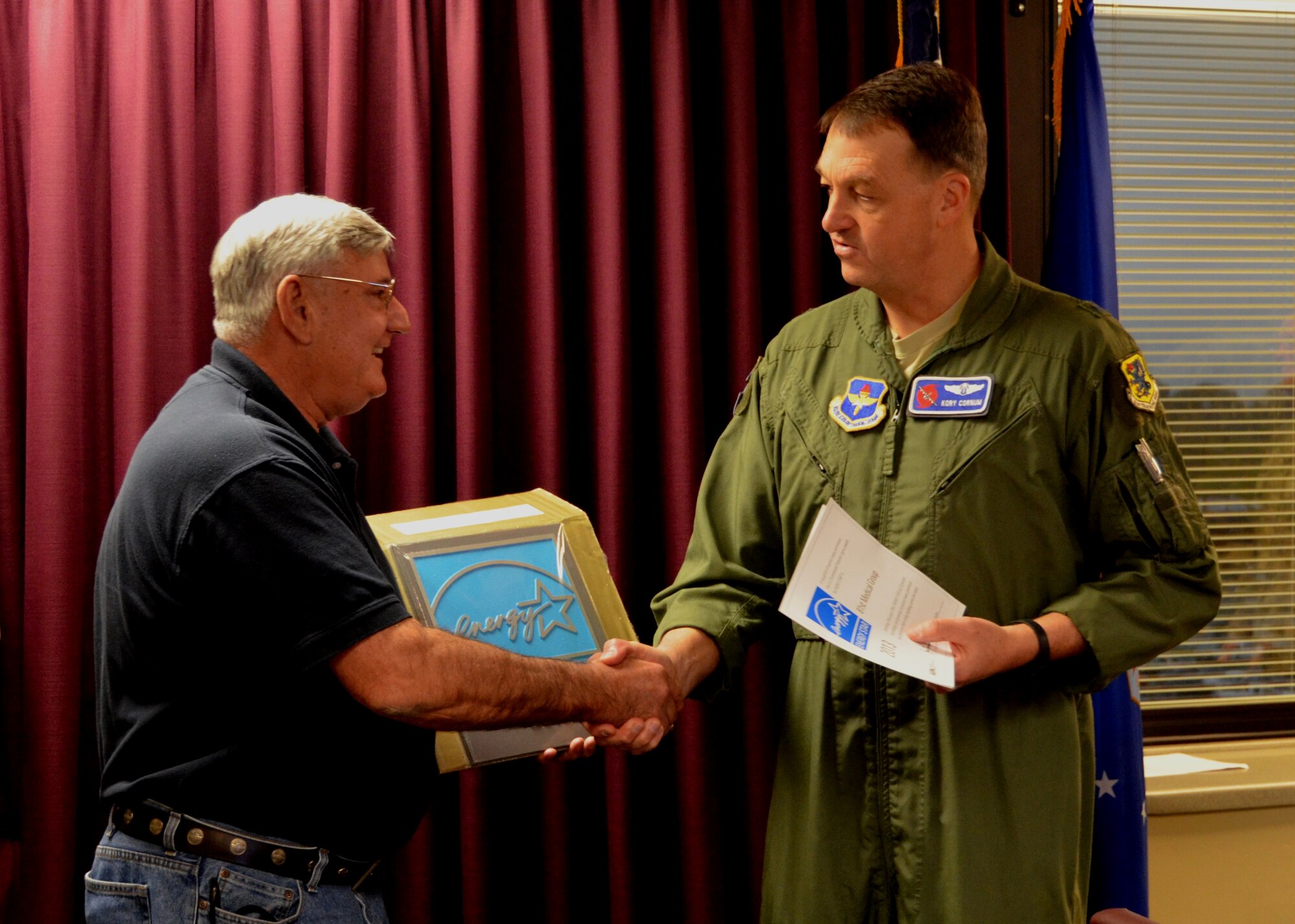 Brig. Gen. (Dr.) Kory Cornum, Keesler Medical Center commander, congratulates facility manager Michael Chatham, 81st Medical Support Squadron, after presenting him the second consecutive Environmental Protection Agency Energy Star Award earned by the medical center.(U.S. Air Force photo by Steve Pivnick)
