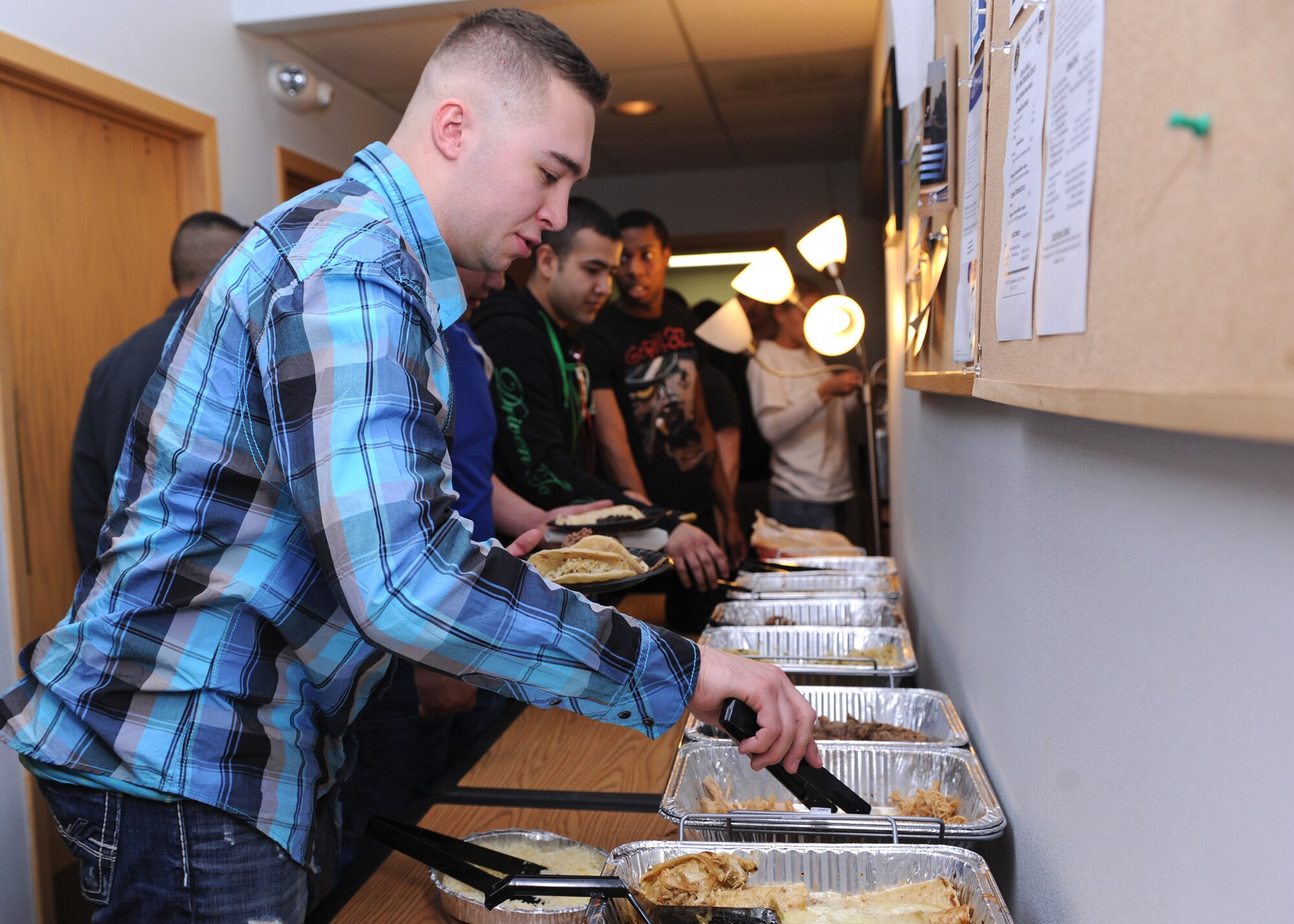 Senior Airman Kyler Pierce, 341st Logistics Readiness Squadron vehicle management technician, fills his plate with food during a free dinner for junior enlisted Airmen at the Malmstrom Detour on Feb. 18. More than 70 Airmen attended the event, to kick off the Detour’s new hours, which are 7:30 a.m. to 10 p.m. Monday through Friday and Saturday from 3 to 8 p.m. (U.S. Air Force photo/Senior Airman Katrina Heikkinen)  
 
