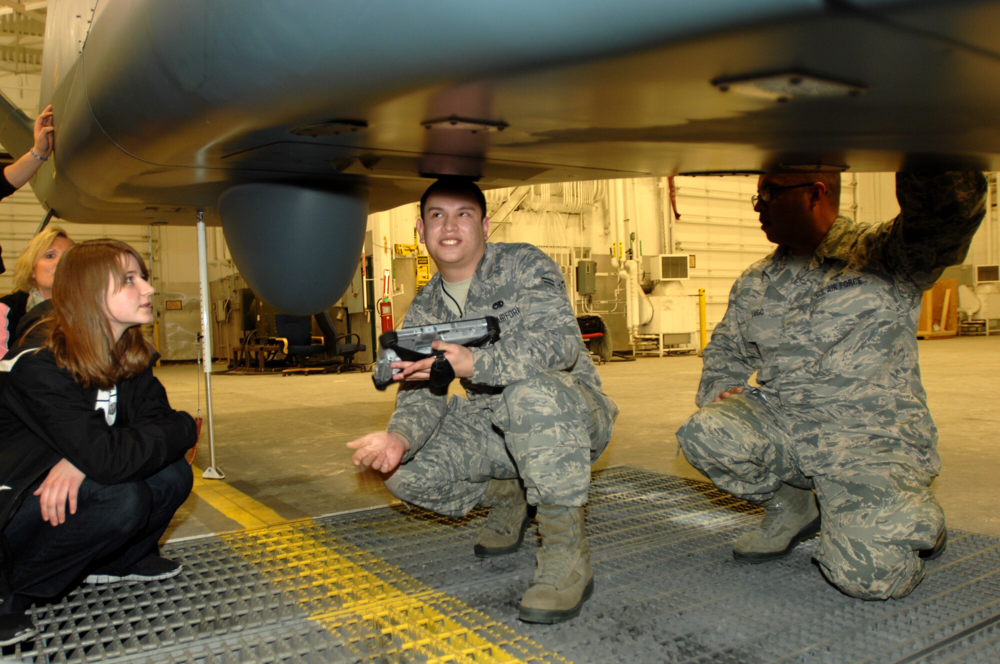 Airman 1st Class Fred Romero, left, 69th Maintenance Squadron RQ-4 Global Hawk Avionics Systems Apprentice, and Staff Sgt. Alfredo Lugo, 69th Maintenance Squadron RQ-4 Global Hawk Avionics Systems Craftsman, give local high school students a tour of the their workplace Feb. 18, 2014, on Grand Forks Air Force Base, N.D. More than three dozen students from four local high schools visited Grand Forks Air Force Base this week to learn about possible careers in the military. (U.S. Air Force photo/Staff Sgt. Susan L. Davis)