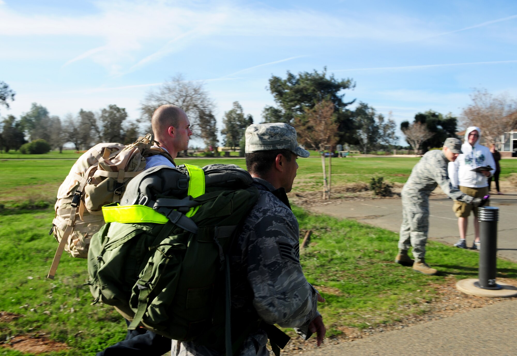 Senior Airman Nick Akley (left), and Staff Sgt. Oscar Vargas, cross the finish line after completing a 10K run with 40-pound rucksacks at Beale Air Force Base, Calif., Feb. 20, 2014. (U.S. Air Force photo by Airman 1st Class Bobby Cummings/Released)