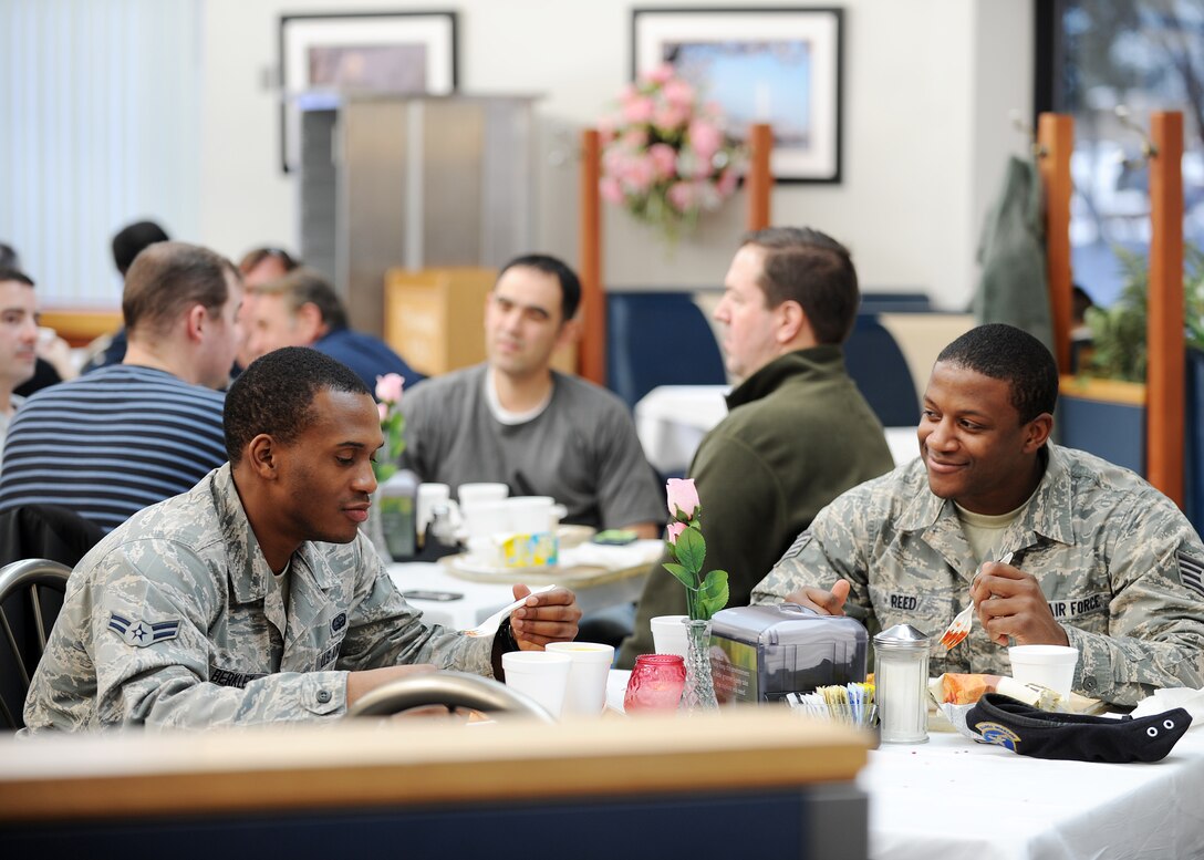 Airman 1st Class Demonte Berkley and Staff Sgt. Brandon Reed eat lunch at Freedom Hall Dining Facility Feb. 14. During the service, evaluators from the National Restaurant Association graded the facility on multiple aspects. The 58th Annual Hennessy Trophy Awards Program Competition grades facilities on categories including; kitchen operations, serving and dining, training and sanitation and maintenance. Airman Demonte is a Knowledge Operations manager and Sergeant Reed is a Confinement Non-commissioned officer, both are with the 11th Security Forces Squadron. (U.S. Air Force photo/Staff Sgt. Nichelle Anderson)