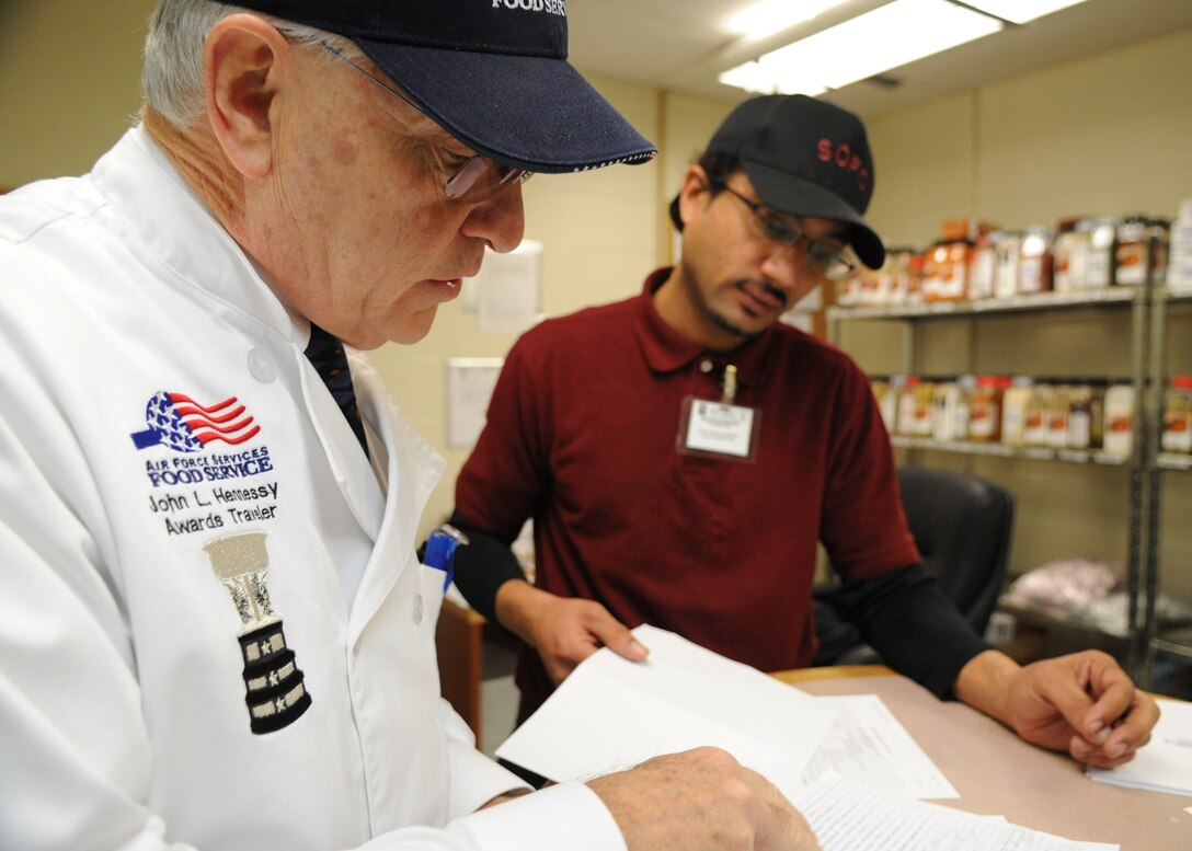 Joseph De Rosa reviews inventory with Kenneth Brown during a Hennessey Evaluation at Joint Base Andrews, Md., Feb. 14. This is the first time the facility was nominated to participate in the 58th Annual Hennessy Trophy Awards Program Competition grades facilities on categories including; kitchen operations, serving and dining, training and sanitation and maintenance.  (U.S. Air Force photo/Aimee Fujikawa)