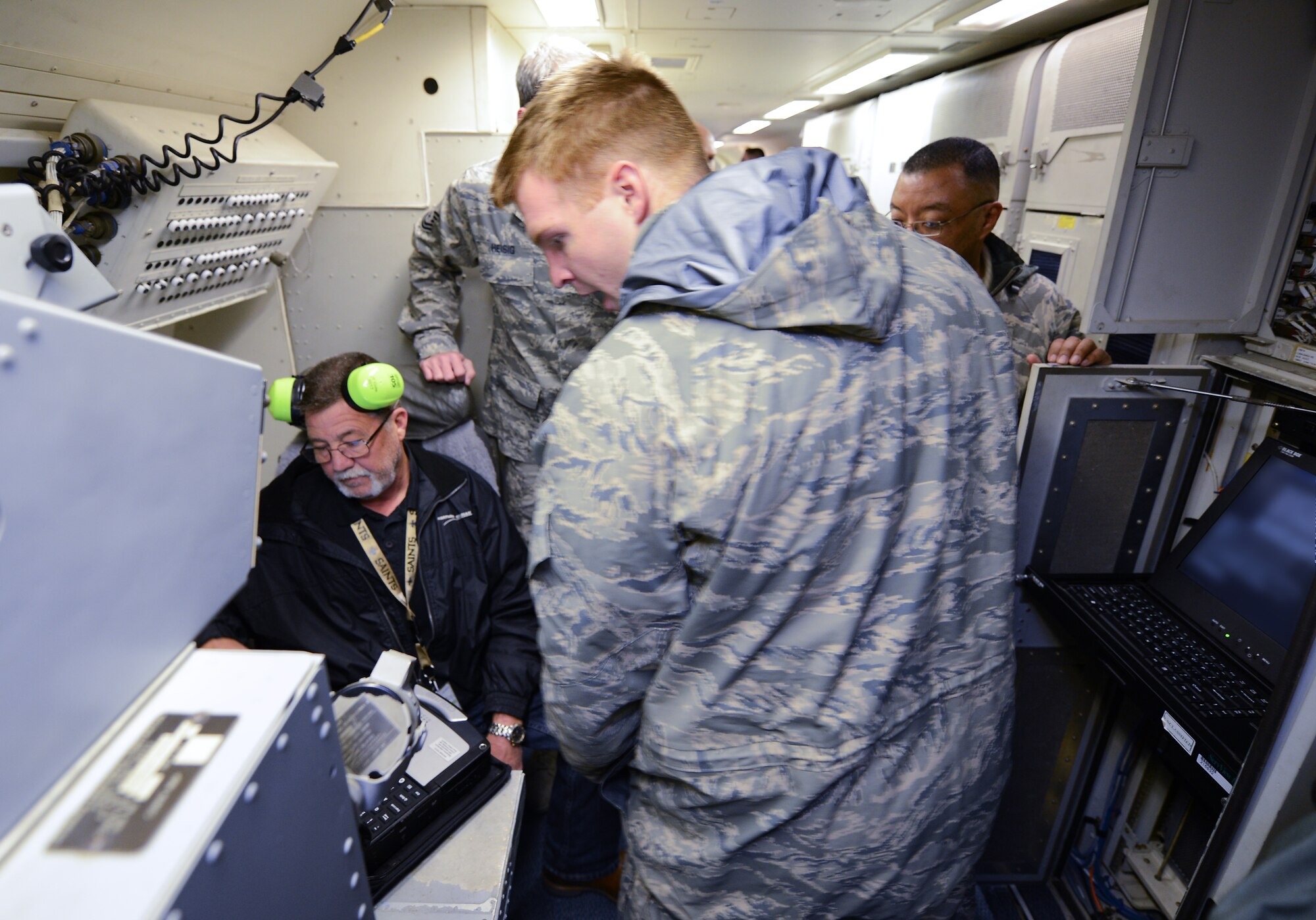 U.S. Air Force Senior Airman Chris Hudson, a communications and navigation technician with the 116th Air Control Wing, Georgia Air National Guard, works with Northrup Grumman Field Service Representative, John Cole, to configure the Joint Range Extension Applications Protocol (JREAP-C) system on an E-8C Joint STARS, Robins Air Force Base, Ga., Feb. 4, 2014. The JREAP-C system was being configured for the first test flight aboard the E-8C. The JREAP-C technology will allow JSTARS operators to receive and transmit data beyond line of sight to more joint agencies at a farther distance than previously possible.  (A portion of the photo has been blurred for security purposes)(U.S. Air National Guard photo by Master Sgt. Roger Parsons/Released)

