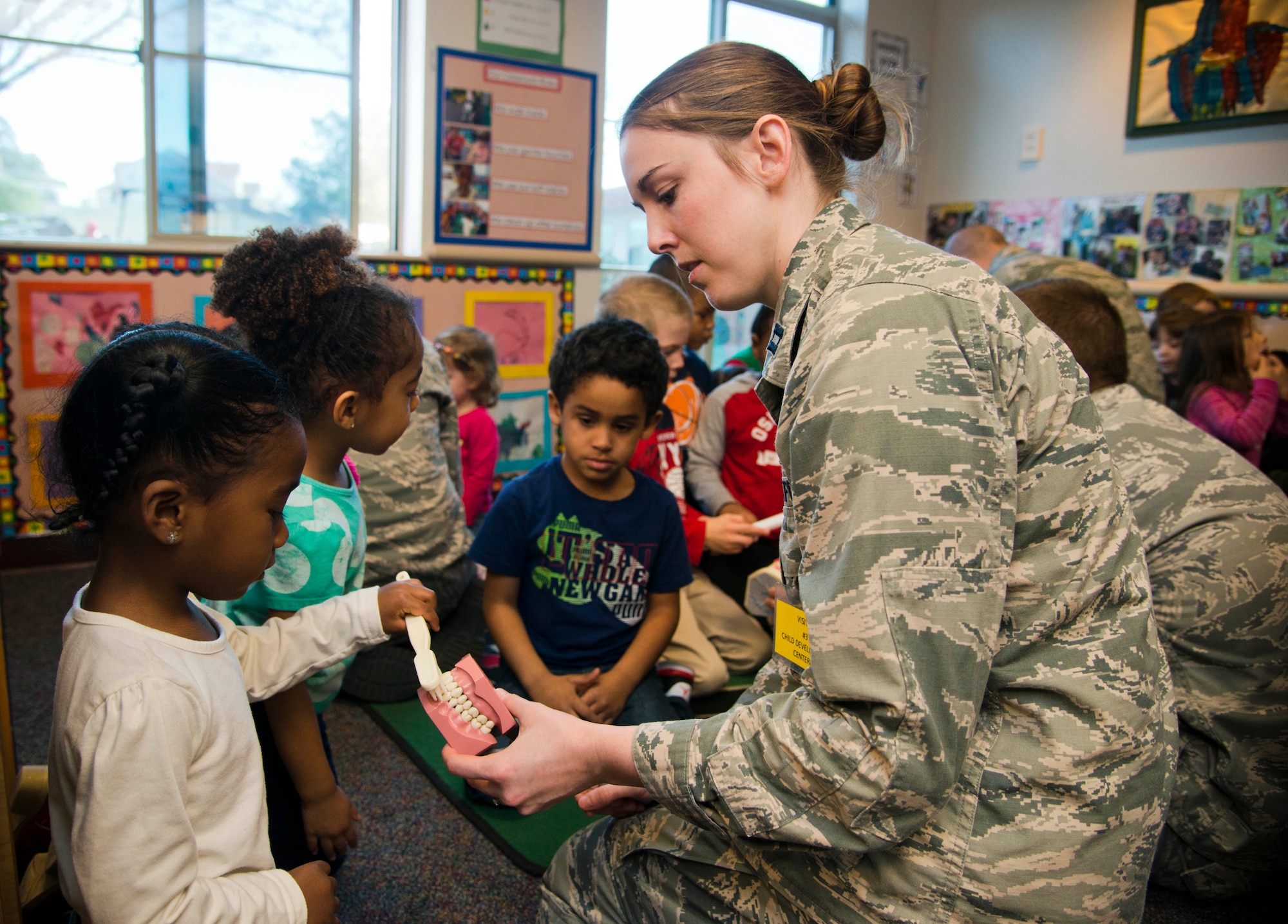 Capt. Ashley Clark, 60th Dental Squadron dentist, shows preschoolers at Child Development Center 3 how to properly brush and floss their teeth. In support of National Children's Dental Month, the squadron visited the elementary schools and CDCs at Travis this week to perform oral health presentations. (U.S. Air Force photo/Senior Airman Nicole Leidholm)