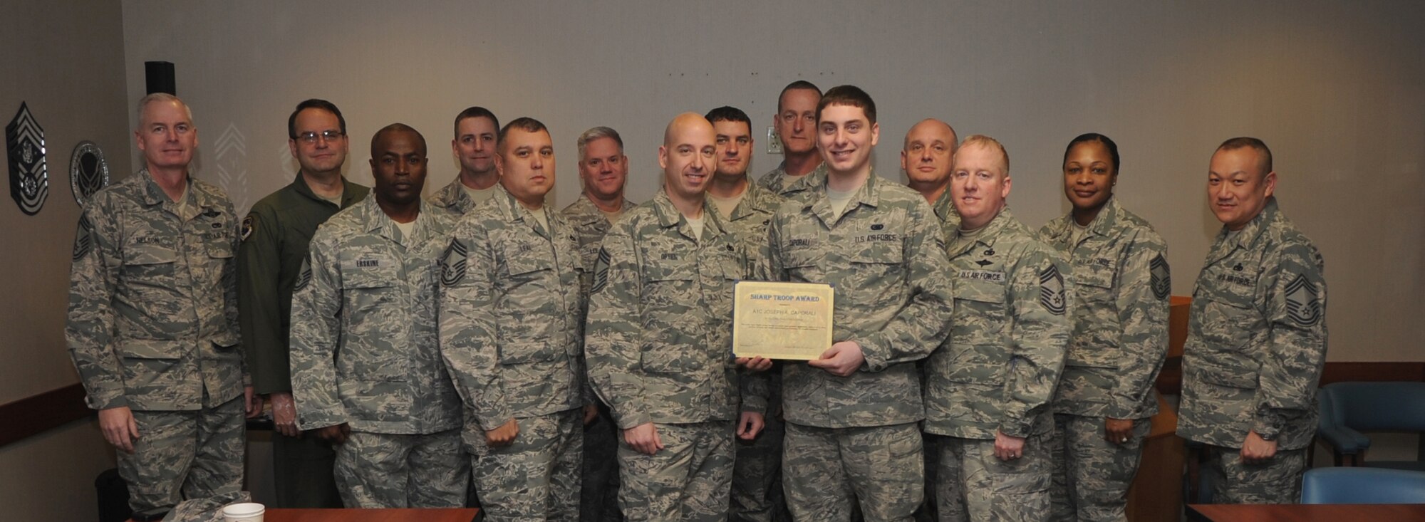 Team Little Rock chiefs pose for a photo with Airman 1st Class Joseph Caporali, a 19th Logistics Readiness Squadron fuels distribution operator, for selection of the Chiefs Group Sharp Troop Award Feb. 18, 2014, at Little Rock Air Force Base, Ark. Caporali was awarded the award for safely refueling 56 C-130 aircraft with more than 120,000 gallons of jet fuel. He also maintained a 10-minute aircraft response time, exceeding the Air Force standard by 66 percent. (U.S. Air Force photo by Staff Sgt. Caleb Pierce)

