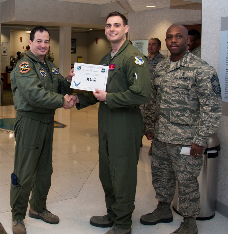 Second Lt. Anthony Cosentino, center, 47th Medical Operations Squadron Aerospace and Operational Physiology officer, poses with Col. Mark Doria, left, 47th Flying Training Wing vice commander, and Chief Master Sgt. Adam Mccomb, 47th Medical Group superintendent, after being presented the XLer of the week award here Feb. 5, 2014. The XLer is a weekly award chosen by wing leadership and given to those who consistently make outstanding contributions to Laughlin and their unit. (U.S. Air Force photo/Airman 1st Class Jimmie D. Pike)