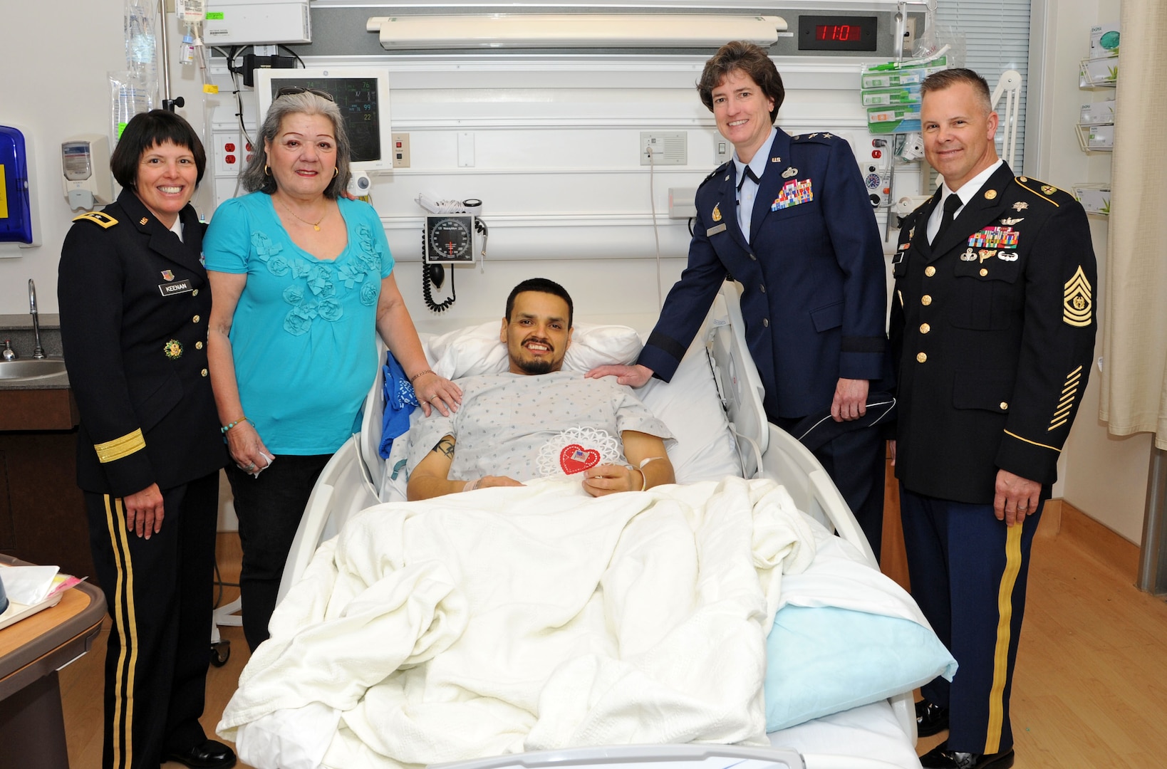 (From left to right) Army Maj. Gen. Jimmie Keenan, Southern Regional Medical Command commander,Olga Alcoser, mother of Army veteran Maximiliano Martinez, Maximiliano M. Martinez, Army veteran, Air Force Maj. Gen. Peggy Poore, Air Force Personnel Center commander and Army Command Sgt. Maj. Jayme D. Johnson, Southern Regional Medical Command command sergeant major, pose for a photo during the 2014 National Salute to Veteran Patients Feb. 14 at the Audie Murphy VA Hospital in San Antonio. The Joint Base San Antonio military ambassadors and JBSA military leaders were on hand to distribute valentines and visit with veteran patients. Veterans administration facilities across the United States pay tribute to veteran patients annually during this week-long salute. (U.S. Air Force photo by Melissa Peterson)