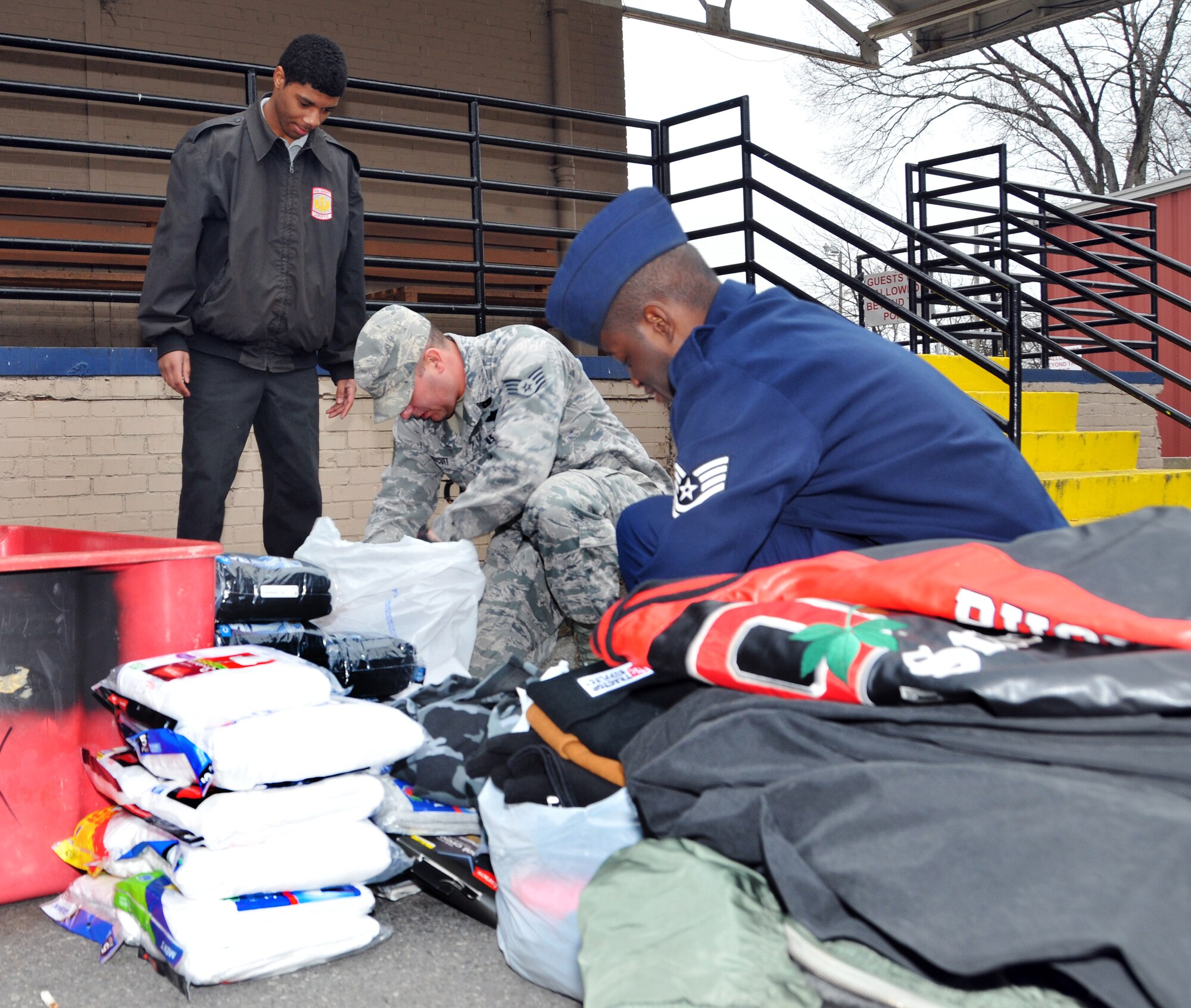 U.S. Air Force Tech. Sgt. Lonnie Brooks, Vice President of the 145th Airlift Wing’s Chapter 7 Association, Director at Large, Staff Sgt. Jessie Huneycutt and Gregory Landrum, a student from Military Global Leadership Academy, a high school located in Charlotte, N.C., sort through men’s coats, hats, gloves and other items donated by members of the North Carolina Air National Guard.  Warm clothes were delivered to the local men’s shelter just as another winter storm pelted Charlotte, N.C. leaving a blanket of snow and ice and many homes without power. (U.S. Air National Guard photo by Master Sgt. Patricia F. Moran/Released) 