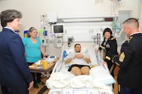 Maximiliano M. Martinez, Army veteran, center, and his mother, Olga Alcoser, back left, are greeted by Army Maj. Gen. Jimmie Keenan, Southern Regional Medical Command commander, back right, Air Force Maj. Gen. Peggy Poore, Air Force Personnel Center commander, left, and Army Command Sgt. Maj. Jayme D. Johnson, Southern Regional Medical Command command sergeant major, right, during the 2014 National Salute to Veteran Patients Feb. 14 at the Audie Murphy VA Hospital in San Antonio.  The Joint Base San Antonio military ambassadors and JBSA military leaders were on hand to distribute valentines and visit with veteran patients. Veterans administration facilities across the United States pay tribute to veteran patients annually during this week-long salute. (U.S. Air Force photo by Melissa Peterson)