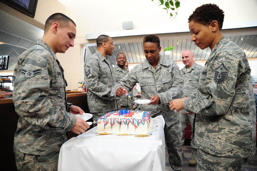 Service members gather around to cut and serve cake during the First Quarter Birthday Meal at Freedom Hall Dining Facility on Joint Base Andrews, Md., Feb. 18. The cake, cut by the youngest service member, celebrates birthdays of Airmen born between the months of January to March. The meal consisted of lobster tail or fried shrimp and steak, a baked potato, corn, broccoli, side salad and cake. The event is free of charge takes place each quarter. (U.S. Air Force photo/ Airman 1st Class Joshua R.M. Dewberry)