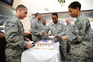 Service members gather around to cut and serve cake during the First Quarter Birthday Meal at Freedom Hall Dining Facility on Joint Base Andrews, Md., Feb. 18. The cake, cut by the youngest service member, celebrates birthdays of Airmen born between the months of January to March. The meal consisted of lobster tail or fried shrimp and steak, a baked potato, corn, broccoli, side salad and cake. The event is free of charge takes place each quarter. (U.S. Air Force photo/ Airman 1st Class Joshua R.M. Dewberry)