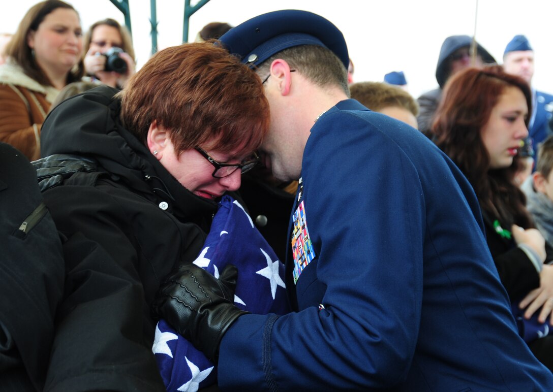 The mother of Tech. Sgt. Dale Mathews is handed a flag in honor of his service during his funeral at Arlington National Cemetery, Va., on Feb 5, 2014. Mathews was a special mission aviator with the 56th rescue squadron at Lakenheath Air Base who passed away in a helicopter crash in England on Jan. 7. Mathews was honored by former service members he was stationed with at Andrews in 2004 and is survived by his four children, wife and parents.  (U.S. Air Force photo/ Airman 1st Class Joshua R.M. Dewberry)