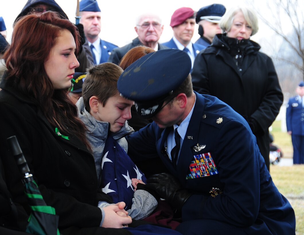 One of the children of Tech. Sgt. Dale Mathews, who passed away in a helicopter crash in England on Jan. 7, is handed a flag during his father's funeral at Arlington National Cemetery, Va., on Feb 5, 2014. Mathews was a special mission aviator with the 56th rescue squadron at Lakenheath Air Base. Mathews was honored by former service members he was stationed with at Andrews in 2004, as well as active-duty Airmen who traveled from around the world to attend his service. He is survived by his four children, wife and parents.  (U.S. Air Force photo/ Airman 1st Class Joshua R.M. Dewberry)