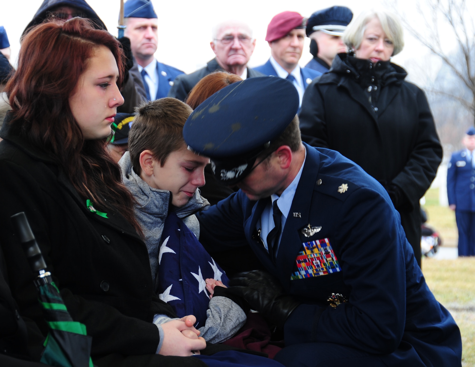 One of the children of Tech. Sgt. Dale Mathews, who passed away in a helicopter crash in England on Jan. 7, is handed a flag during his father's funeral at Arlington National Cemetery, Va., on Feb 5, 2014. Mathews was a special mission aviator with the 56th rescue squadron at Lakenheath Air Base. Mathews was honored by former service members he was stationed with at Andrews in 2004, as well as active-duty Airmen who traveled from around the world to attend his service. He is survived by his four children, wife and parents.  (U.S. Air Force photo/ Airman 1st Class Joshua R.M. Dewberry)