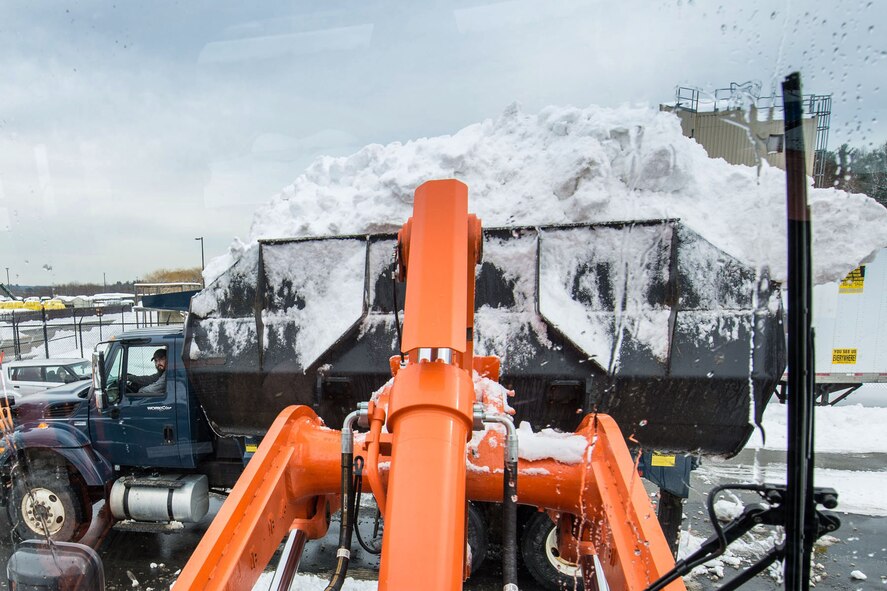 HANSCOM AIR FORCE BASE, Mass. – Peter Crory, a member of the Civil Engineer snow removal team, sits in his truck and watches as a front loader removes mounting snow that is accumulating in parking lota and other areas on base Feb. 19. The Civil Engineer snow removal team has been busy plowing and removing snow from parking lots around base this winter. (U.S. Air Force photo by Rick Berry)