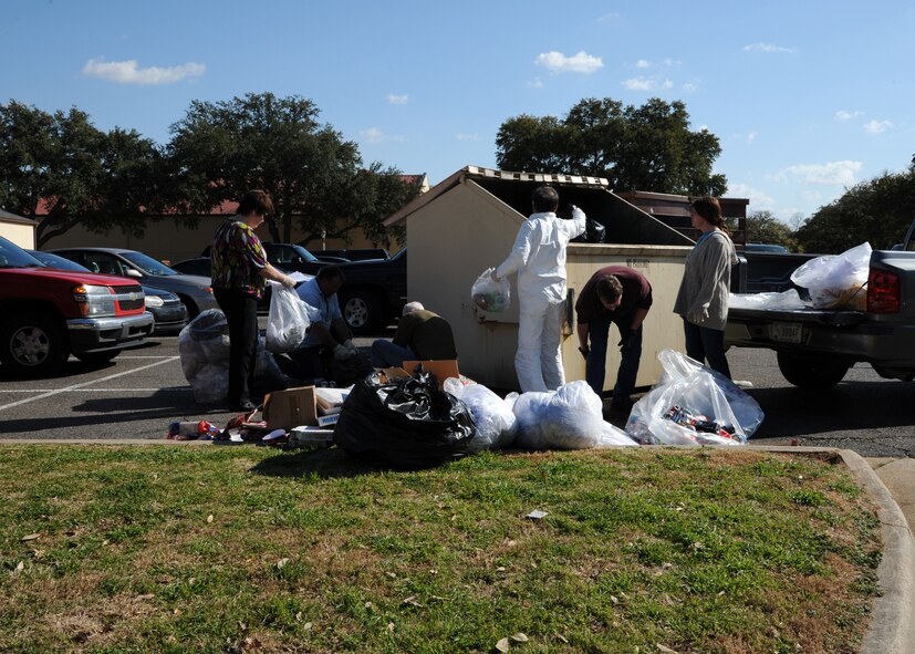 Environmental specialists from the 2nd Civil Engineer Squadron perform a dumpster dive on Barksdale Air Force Base, La., Feb. 14, 2014. A dumpster dive is a random inspection of a refuse container to determine how many recyclables are being recycled improperly. The team found that 50 percent of the items in the trash container should have been recycled. (U.S. Air Force photo/Senior Airman Joseph A. Pagán Jr.)