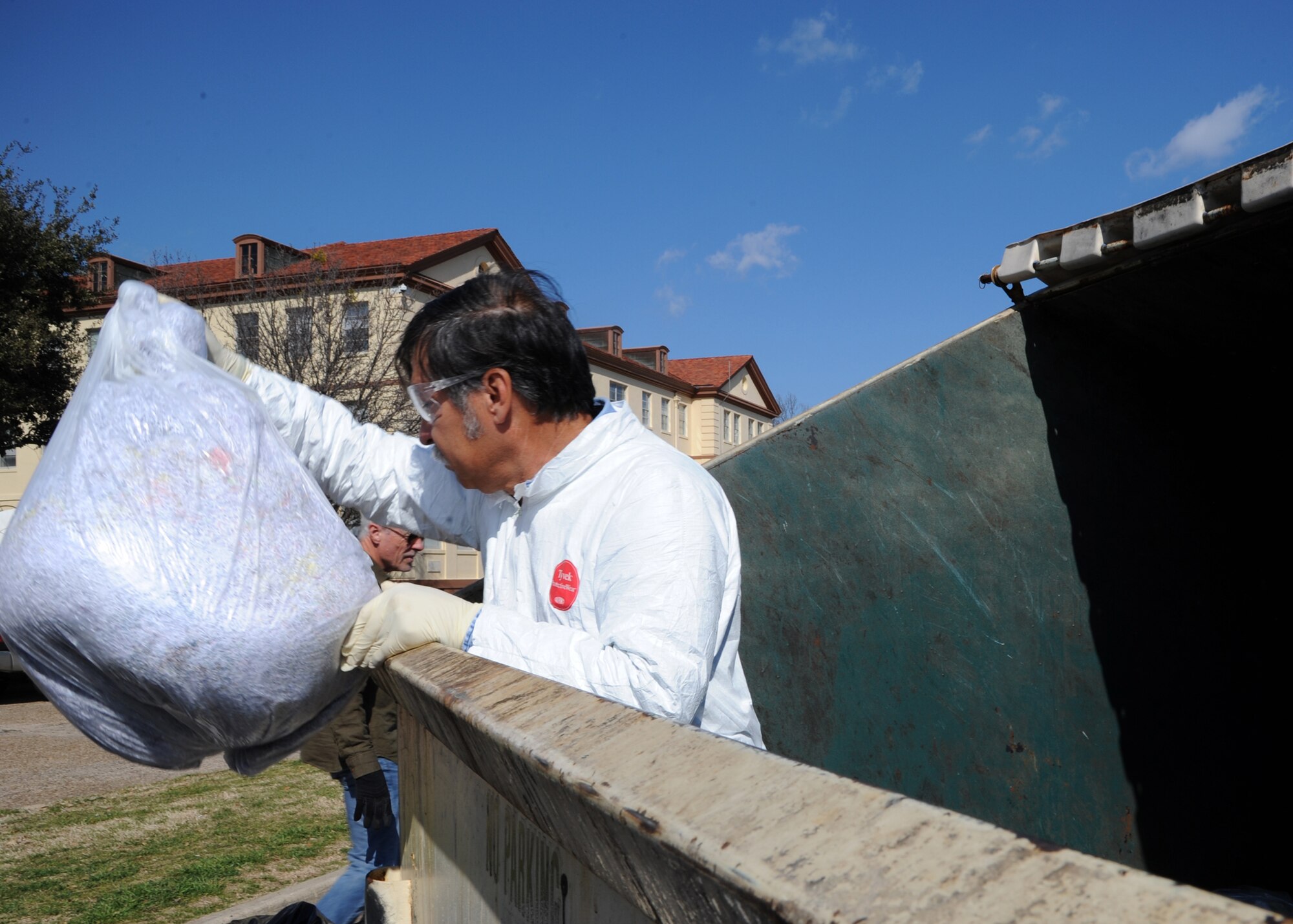 Alfredo Garza, 2nd Civil Engineer Squadron recycling manager, removes shredded paper from a waste container on Barksdale Air Force Base, La., Feb. 14, 2014. Along with bags of paper, Garza found cans, plastic bottles and cardboard placed in the wrong container. (U.S. Air Force photo/Senior Airman Joseph A. Pagán Jr.)