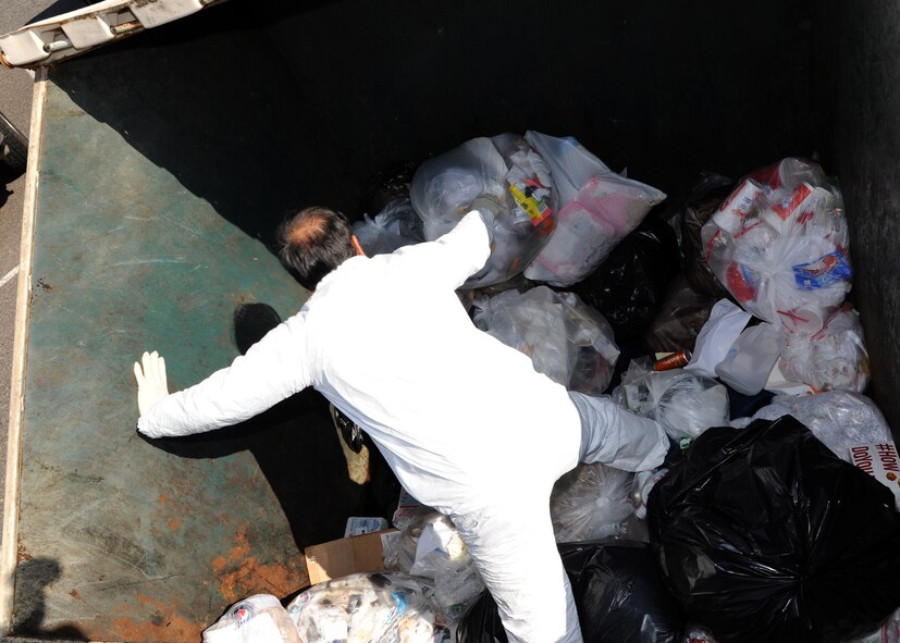 Alfredo Garza, 2nd Civil Engineer Squadron recycling manager, sorts through trash in a waste container on Barksdale Air Force Base, La., Feb. 14, 2014. Garza performed a random inspection on the dumpster to determine how many recyclable items were improperly disposed of. (U.S. Air Force photo/Senior Airman Joseph A. Pagán Jr.)
