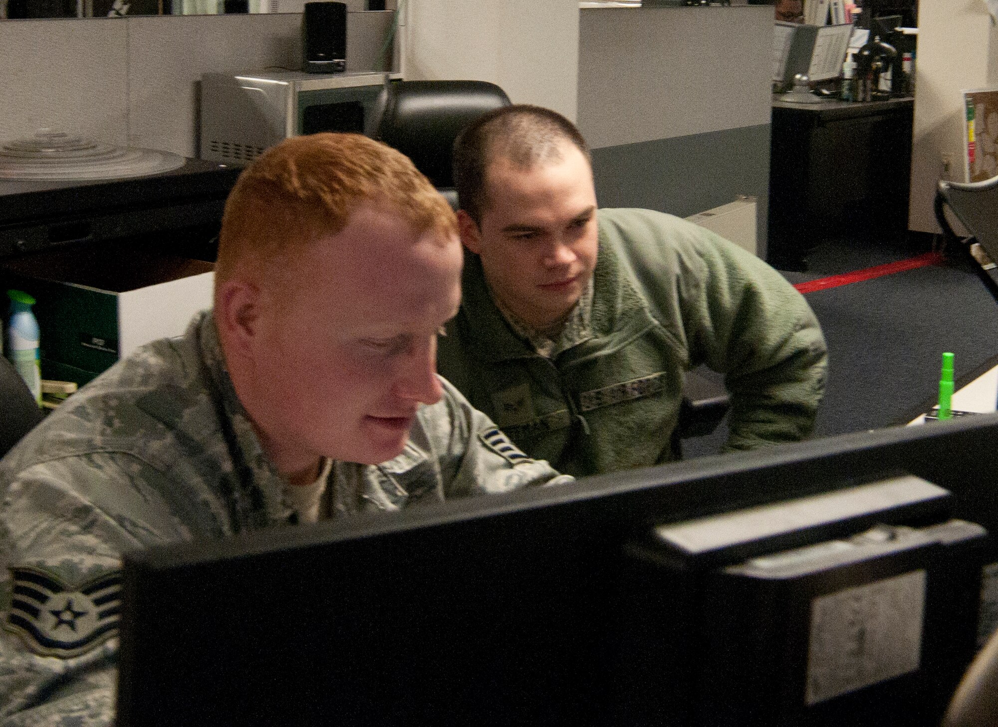 Staff Sgt. Daniel Miller and Senior Airman Christopher Coffman, 90th Security Forces Squadron central security controllers, coordinate security activities in secure sites on F.E. Warren Air Force Base, Wyo., in their work center located in the basement of Building 232 Feb. 14, 2013. (U.S. Air Force photo by Airman 1st Class Jason Wiese)