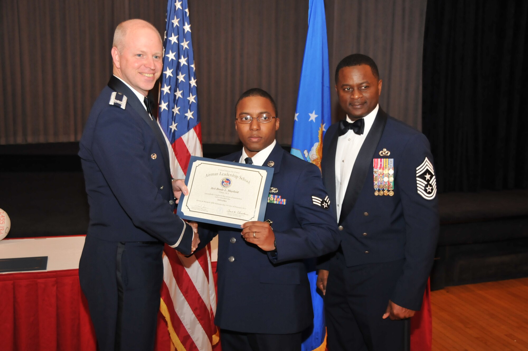 U.S. Air Force Col. Mark Ramsey, Vice Commander 42nd Air Base Wing, and Chief Master Sgt. Harry Hutchinson, Command Chief 42nd Air Base Wing, presents the Airman Leadership School graduating diploma to Senior Airman Brady Mayfield, 187th Security Forces Squadron, at Maxwell Air Force Base, Ala., Feb. 13, 2014. Airman Leadership School teaches leadership and supervisory skills to Senior Airmen and is required for Airmen to become Noncommissioned Officers.(U.S. Air Force photo by Tech. Sgt. Matthew Garrett)