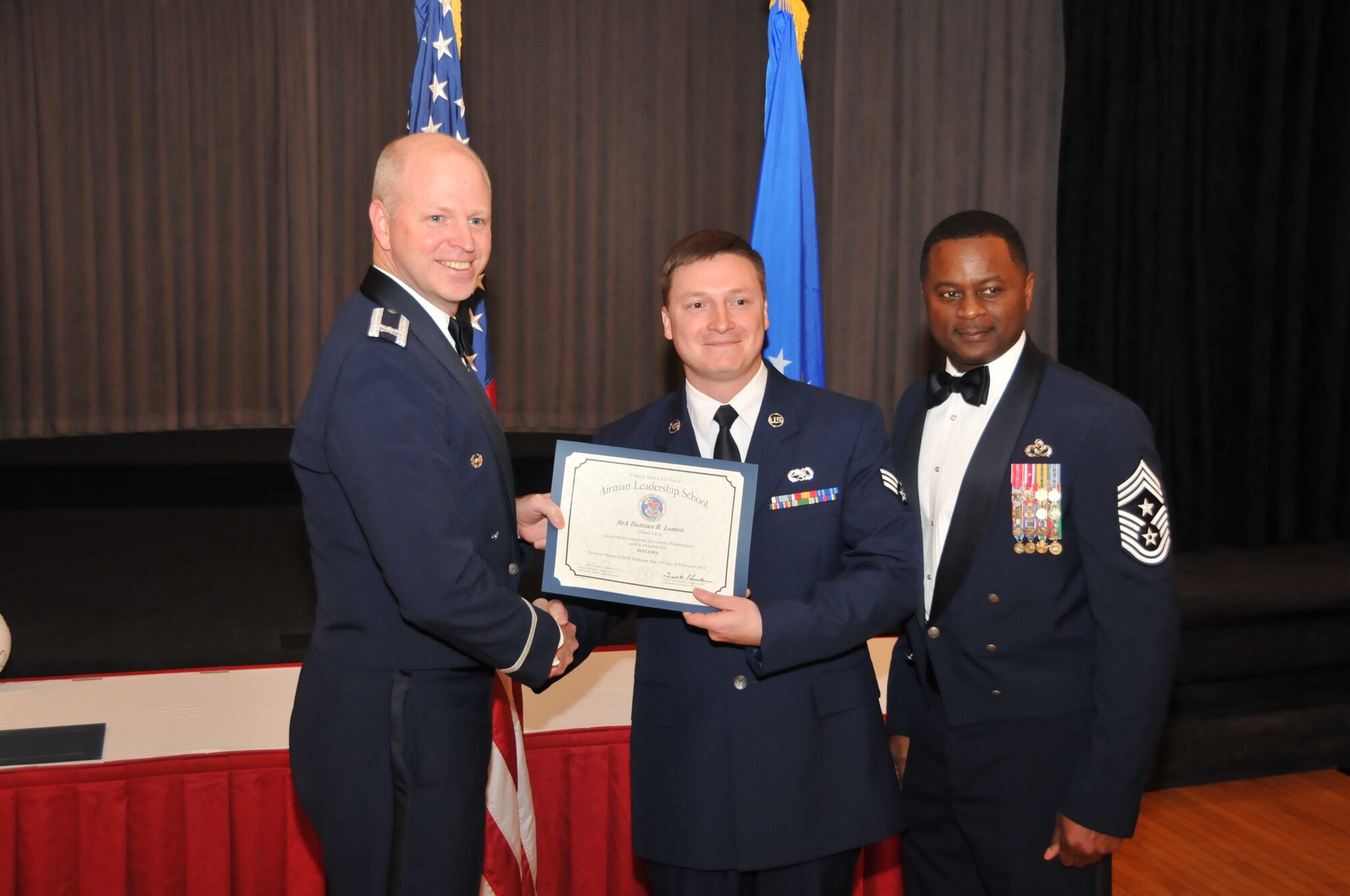 U.S. Air Force Col. Mark Ramsey, Vice Commander 42nd Air Base Wing, and Chief Master Sgt. Harry Hutchinson, Command Chief 42nd Air Base Wing, presents the Airman Leadership School graduating diploma to Senior Airman Damian Lomeli, 187th Aircraft Maintenance Squadron, at Maxwell Air Force Base, Ala., Feb. 13, 2014. Airman Leadership School teaches leadership and supervisory skills to Senior Airmen and is required for Airmen to become Noncommissioned Officers.(U.S. Air Force photo by Tech. Sgt. Matthew Garrett)