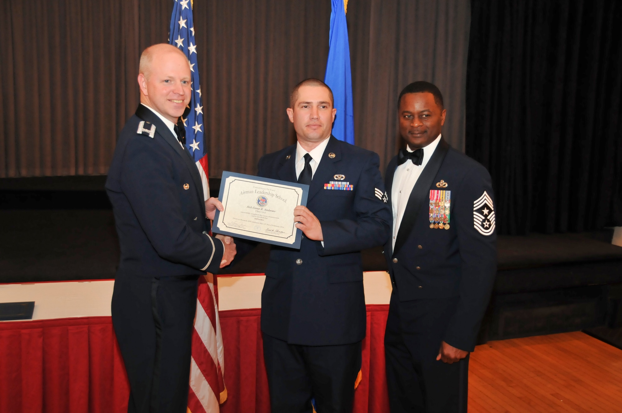 U.S. Air Force Col. Mark Ramsey, Vice Commander 42nd Air Base Wing, and Chief Master Sgt. Harry Hutchinson, Command Chief 42nd Air Base Wing, presents the Airman Leadership School graduating diploma to Senior Airman Corey Andrews, 187th Civil Engineer Squadron, at Maxwell Air Force Base, Ala., Feb. 13, 2014. Airman Leadership School teaches leadership and supervisory skills to Senior Airmen and is required for Airmen to become Noncommissioned Officers.(U.S. Air Force photo by Tech. Sgt. Matthew Garrett)