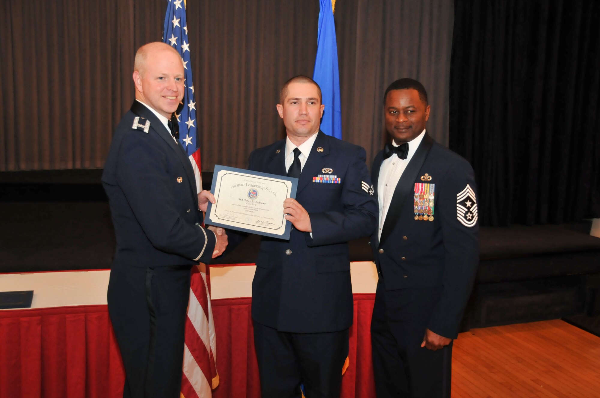 U.S. Air Force Col. Mark Ramsey, Vice Commander 42nd Air Base Wing, and Chief Master Sgt. Harry Hutchinson, Command Chief 42nd Air Base Wing, presents the Airman Leadership School graduating diploma to Senior Airman Corey Andrews, 187th Civil Engineer Squadron, at Maxwell Air Force Base, Ala., Feb. 13, 2014. Airman Leadership School teaches leadership and supervisory skills to Senior Airmen and is required for Airmen to become Noncommissioned Officers.(U.S. Air Force photo by Tech. Sgt. Matthew Garrett)