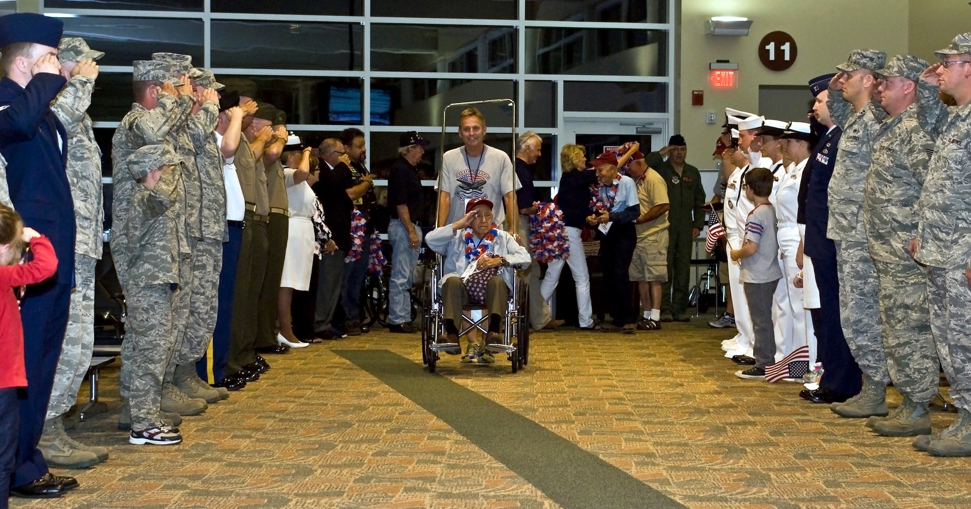 Member of the Illinois Air National Guard's 182nd Airlift Wing and fellow service members salute a U.S. Armed Forces veteran as he makes his return home from the inaugural Greater Peoria Honor Flight at the General Wayne A. Downing Peoria International Airport in Peoria, Ill., June 4, 2013. The photo was one of five by Staff Sgt. Lealan C. Buehrer, photojournalist with the 182nd Airlift Wing, submitted to the National Guard Bureau media contest. Buehrer was announced the winner of the Air National Guard Outstanding New Photographer category on Feb. 3, 2014. (U.S. Air National Guard photo by Staff Sgt. Lealan Buehrer/Released)