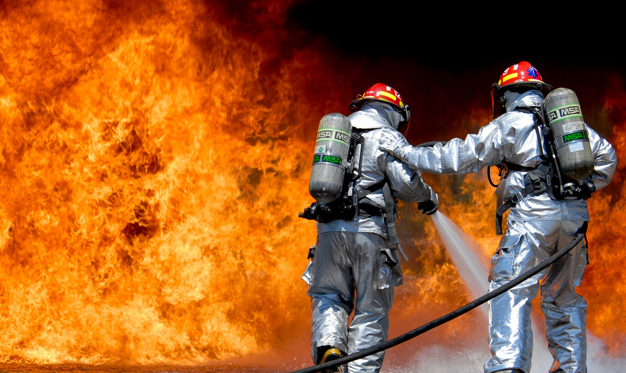 U.S. Air Force firefighters with the 182nd Civil Engineer Squadron combat a kerosene-based jet fuel fire at the 182nd Airlift Wing in Peoria, Ill., May 13, 2013. The firefighters tested the capabilities of their P-34 Rapid Intervention Vehicle’s ultra-high pressure water dispersal technology during the controlled burn exercise. The photo was one of five by Staff Sgt. Lealan C. Buehrer, photojournalist with the 182nd Airlift Wing, submitted to the National Guard Bureau media contest. Buehrer was announced the winner of the Air National Guard Outstanding New Photographer category on Feb. 3, 2014. (U.S. Air National Guard photo by Staff Sgt. Lealan Buehrer/Released)