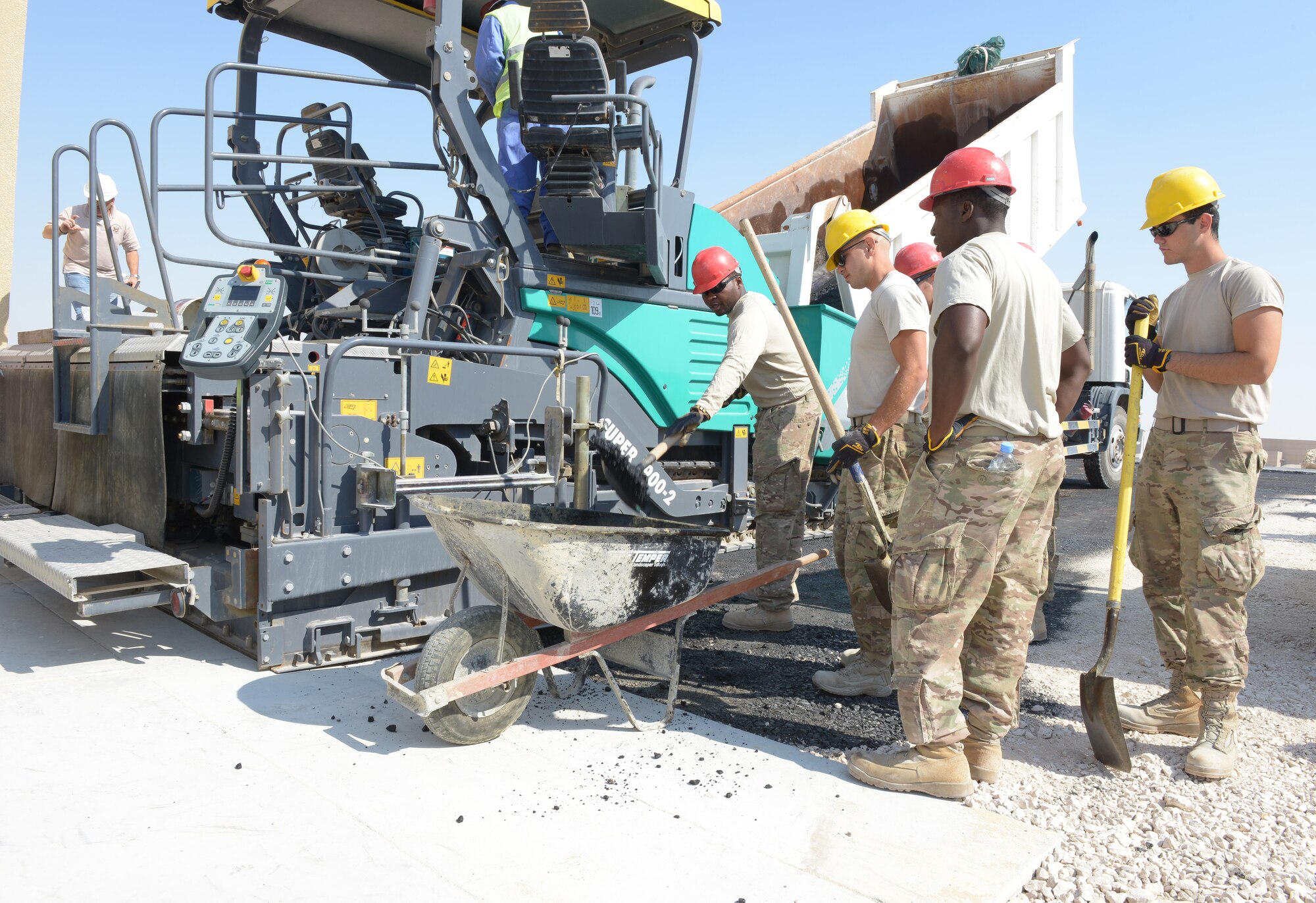 Airmen from the 557th Expeditionary Rapid Engineer Deployable Heavy Operational Repair Squadron Engineer Squadron prepares asphalt prior to building an access road for the new Contingency Aeromedical Staging Facility at Al Udeid Air Base, Qatar, Feb. 19, 2014. The CASF will house and provide medical care to wounded service members prior to medical evacuation. RED HORSE provides heavy repair and construction capabilities throughout the U.S. Air Forces Central Command area of responsibility. (U.S. Air Force photo/Senior Airman Hannah Landeros)