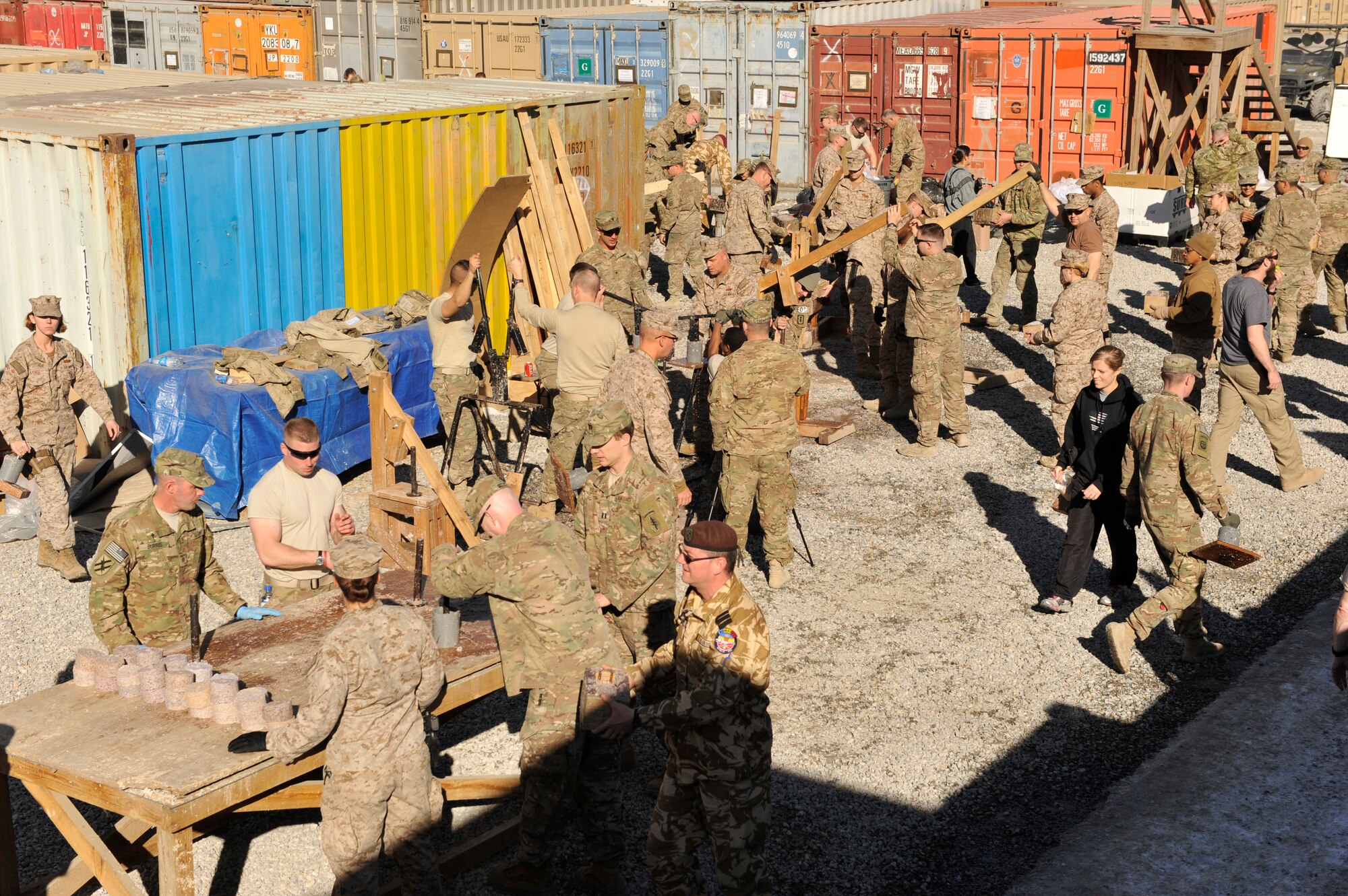 U.S. Service members along with Coalition partners participate in the making of fire donuts, a mixture of wet shredded paper and saw dust, at Camp Phoenix, Afghanistan, Feb. 16, 2014. Service members from all branches along with coalition partners all volunteered to make the fire starters that are later distributed to local Afghan families to use as a source of heat during cold weather.(U.S. Air Force photo by Senior Master Sgt. Gary J. Rihn/Released)