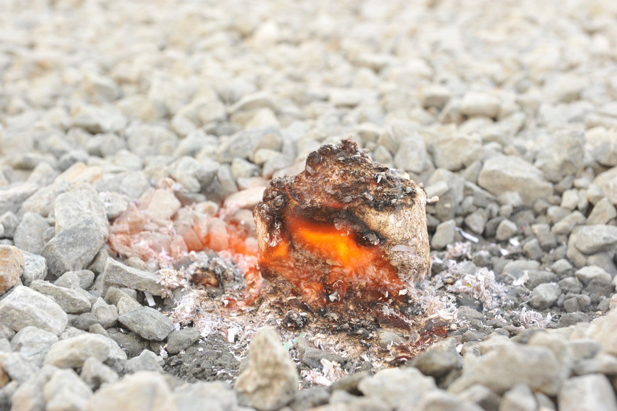 A fire donut, made of a mixture of wet shredded paper and saw dust pressed together in a mold, burns at Camp Phoenix, Afghanistan, Feb. 16, 2014. Service members from all branches along with coalition partners all volunteered to make the fire starters that are later distributed to local Afghan families to use as a source of heat during cold weather.(U.S. Air Force photo by Senior Master Sgt. Gary J. Rihn/Released)