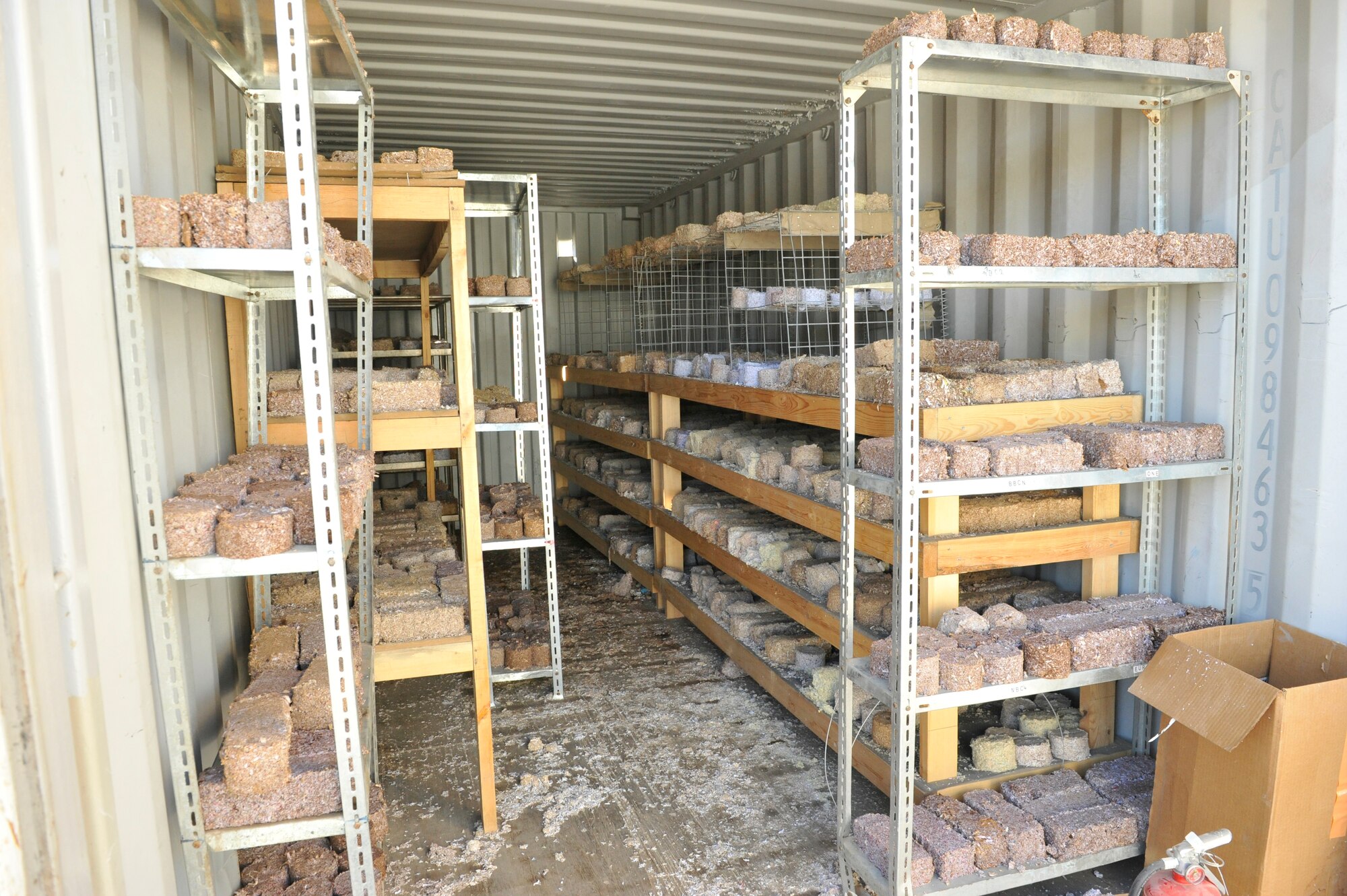 Recently formed fire donuts and fire bricks dry on racks at Camp Phoenix, Afghanistan, Feb. 16, 2014. The fire starters are a mixture of wet shredded paper and saw dust that is placed into a mold, compressed and allowed to dry, then later distributed to local Afghan families to use as a source of heat during cold weather.(U.S. Air Force photo by Senior Master Sgt. Gary J. Rihn/Released)