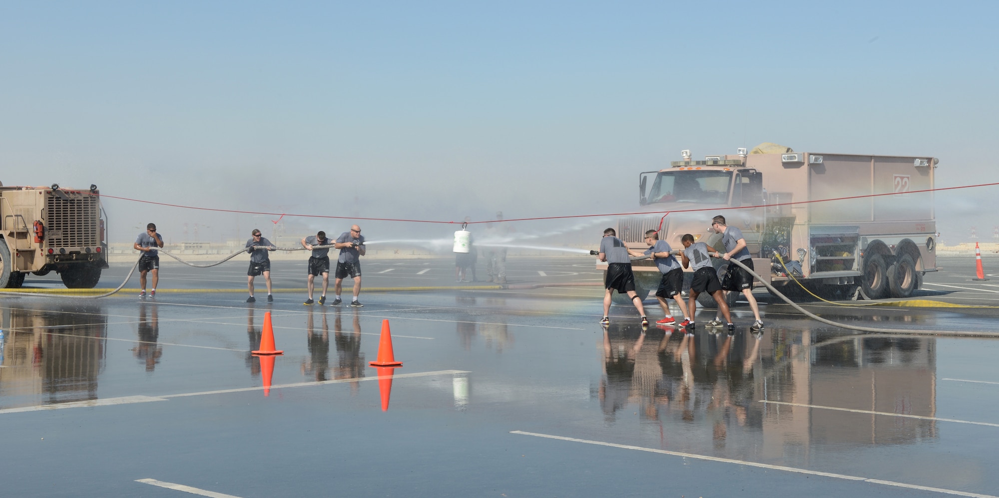 Soldiers deployed to Al Udeid Air Base, Qatar, participate in a water joust during a fire muster Feb. 15, 2014. The fire muster is an obstacle course that consists of seven stations which each team must complete in less than five minutes. Ten teams of four people competed in the fire muster with the winning team completing the course with a time of three minutes and 16 seconds. (U.S. Air Force photo/Senior Airman Hannah Landeros)