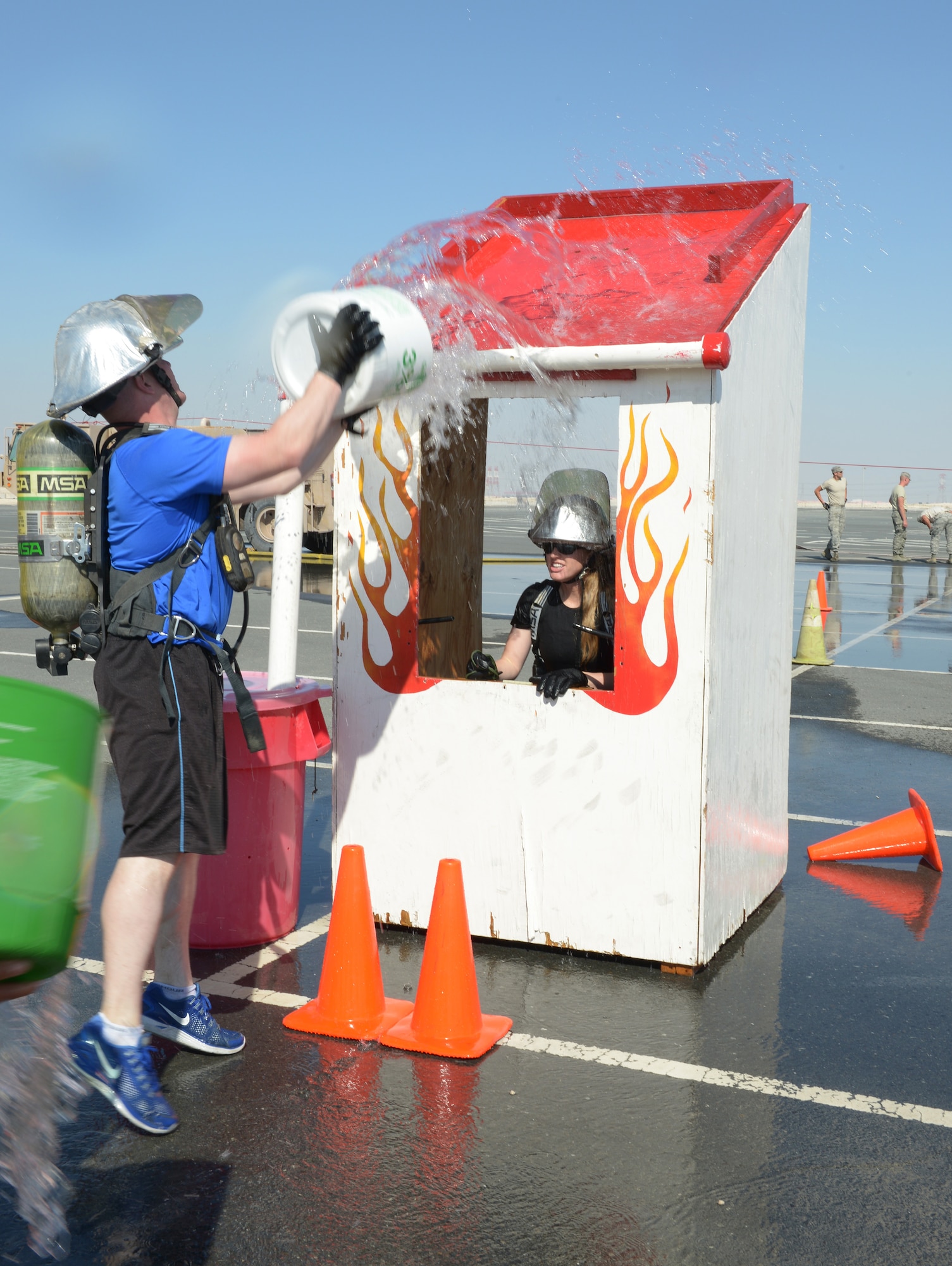 Airmen deployed to Al Udeid Air Base, Qatar, compete in a fire muster Feb. 15, 2014. The fire muster is an obstacle course that consists of seven stations which each team must complete in less than five minutes. Ten teams of four people competed in the fire muster with the winning team completing the course with a time of three minutes and 16 seconds. (U.S. Air Force photo/Senior Airman Hannah Landeros)