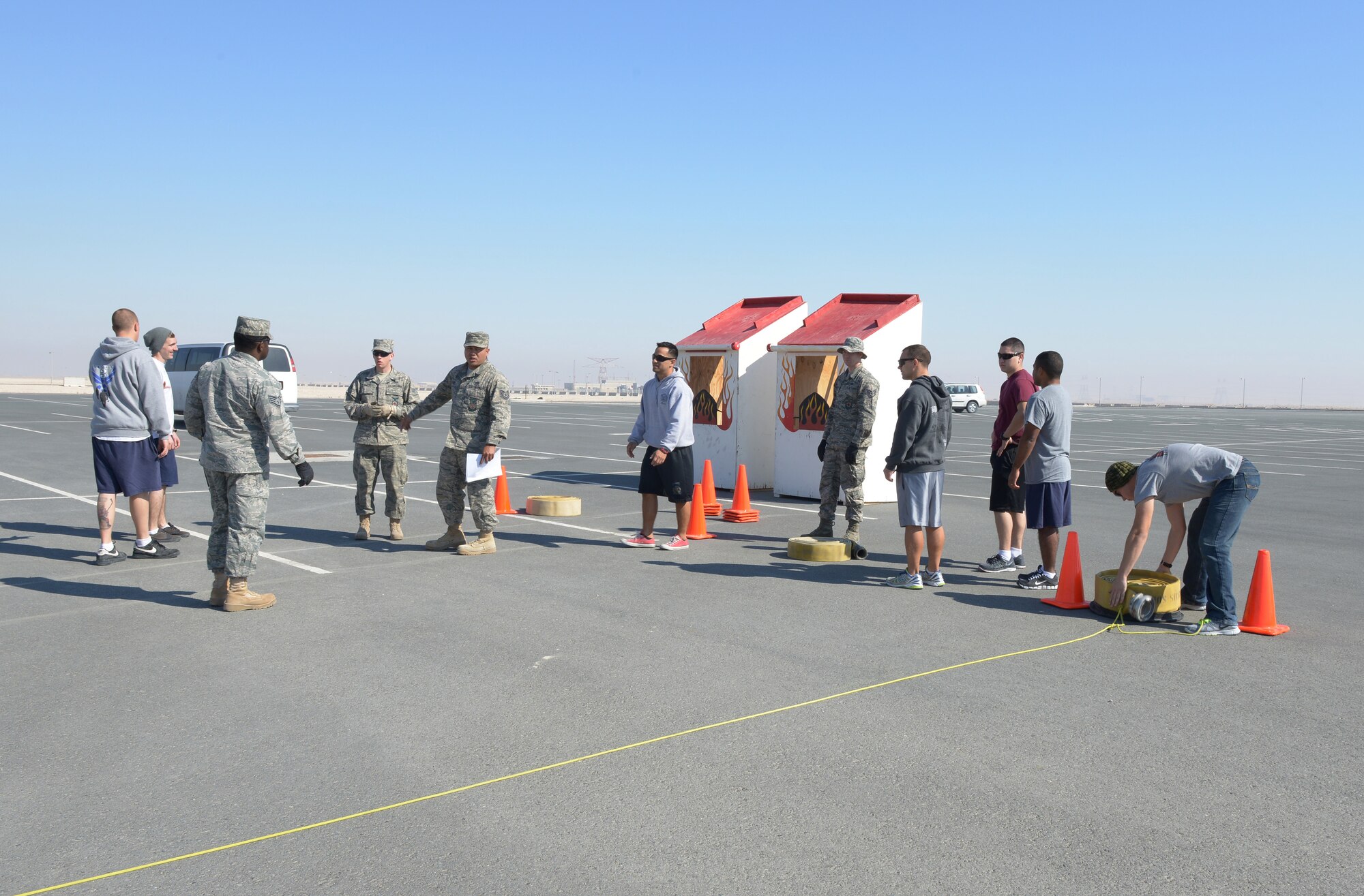 Firefighters from the 379th Expeditionary Civil Engineer Squadron set up for a fire muster at Al Udeid Air Base, Qatar, Feb. 15, 2014. Service members deployed to AUAB competed in a seven station obstacle course to get a taste of some of the training firemen must complete. This is the first fire muster to take place in 2014. (U.S. Air Force photo/Senior Airman Hannah Landeros)