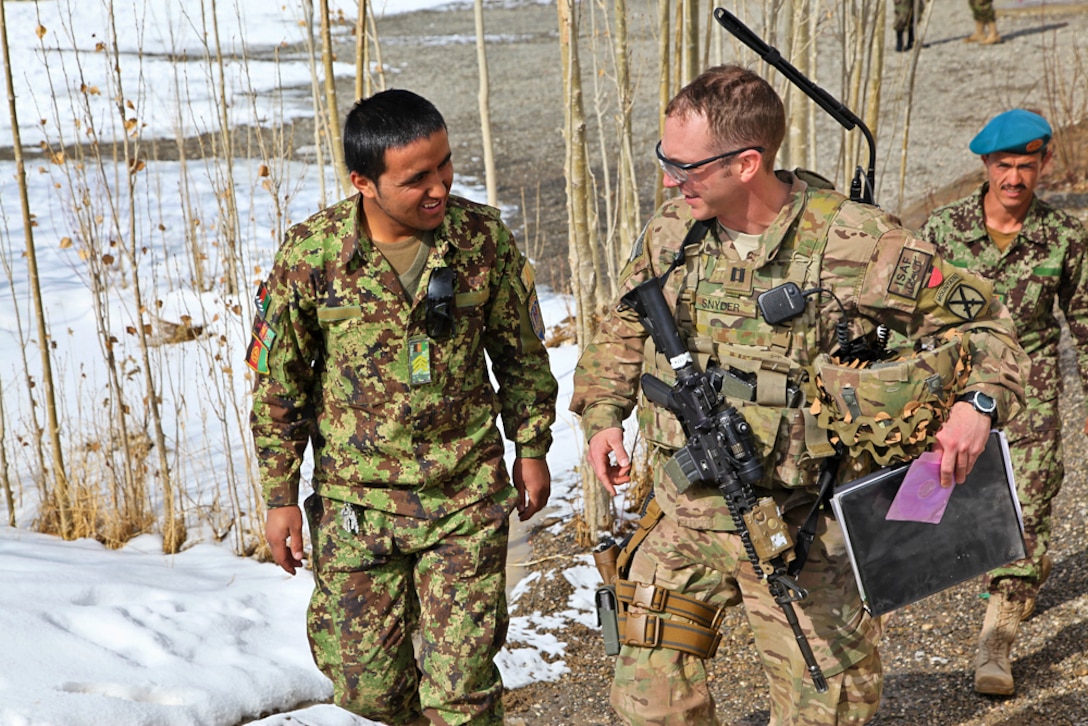 U.S. Army Capt. Joshua Snyder, right, speaks with an Afghan soldier after their weekly visit on Forward Operating Base Thunder in Paktya province, Afghanistan, Feb. 20, 2014. Snyder is assigned to the Engineer Security Force Advise and Assist Team.
