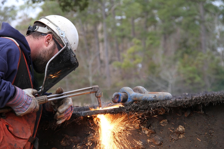 A welder from U.S. Facilities, Inc., based in Philadelphia, Pa., welds a steel eye hook on two ends of the old gate to make it easier for contractors to guide the gate once it is lifted by the crane. Each set of canal gates, which are managed and operated by the Norfolk District, is removed and refurbished on a rotational basis every 15 to 20 years. 