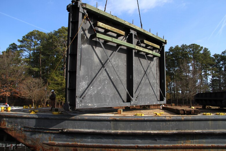 A crane is moving one of two refurbished lock gates off a barge and lowering it into the canal at the Great Bridge Lock Feb. 20, 2014. The 72-ton set of aging lock gates were removed after 25 years - part of a service plan to increase the lifespan of the Great Bridge locks. Each set of canal gates, which are managed and operated by the Norfolk District, is removed and refurbished on a rotational basis every 15 to 20 years. 