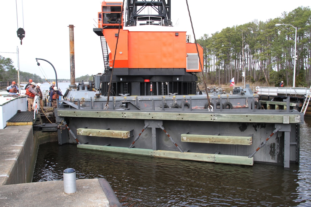 A crane lowers one of two refurbished lock gates into place at the Great Bridge Lock here Feb. 20, 2014 as part of a service plan to increase the lifespan of the lock. The Great Bridge Lock gates, which were constructed by the Corps in 1932, are part of the eight sets of gates throughout the Albemarle and Chesapeake Canal waterway. Each set of canal gates, which are managed and operated by the Norfolk District, is removed and refurbished on a rotational basis every 15 to 20 years. The Albemarle and Chesapeake Canal together with the Dismal Swamp Canal form the historic Atlantic Intracoastal Waterway, which provides pleasure boaters and commercial shippers with a protected inland channel between Norfolk, Va. and Miami, Fla. 
