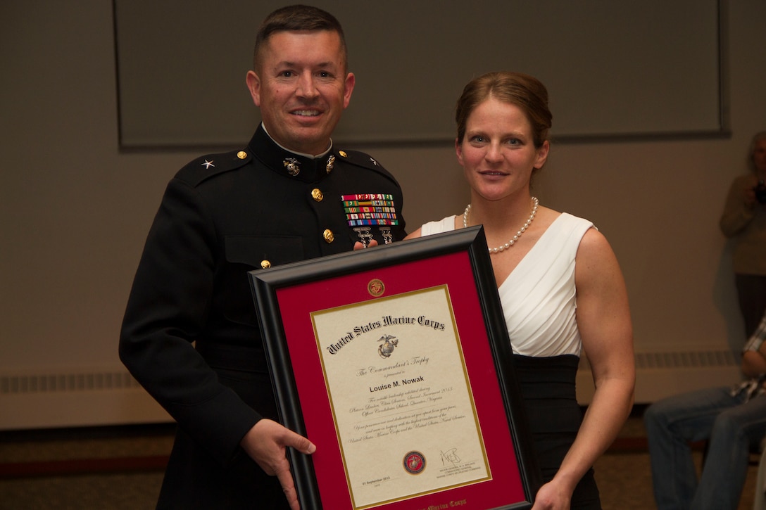 Brig. Gen. James W. Bierman, Commanding General, Western Recruiting Region, presents the Commandant’s Trophy to officer Candidate Louise M. Nowak at Carroll University, Feb. 21, 2014. Candidate Nowak was selected above her peers to receive the Commandant’s Trophy in recognition of her superior academic performance, physical ability and exceptional leadership skills.