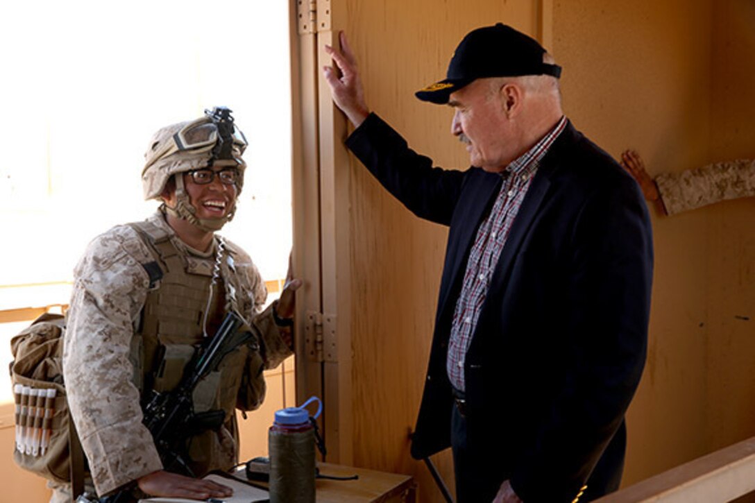 The Honorable Mr. Dennis McGinn, Assistant Secretary of the Navy, Energy, Installations, and Environment, speaks with Pfc. Christopher Hunter, infantryman, Company C, 1st Battalion, 7th Marine Regiment, at Range 210 during his visit to the Combat Center, Feb. 12, 2014.
