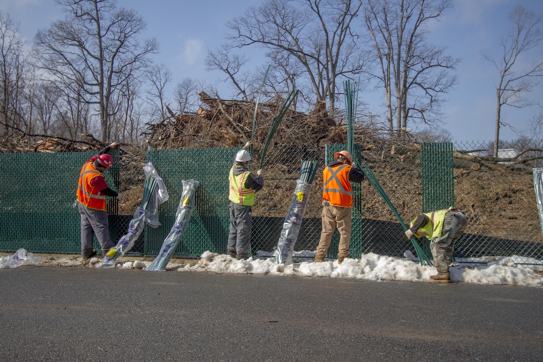 ARLINGTON, Va. -- Juan Benavides, a sub-contractor with Hercules Fencing, places privacy slats into fencing that separates the Millennium Project from the rest of Arlington National Cemetery, Feb. 19, 2014. Contractors are using the fencing to keep the general public out of the active construction area for the 27-acre project, which will add nearly 30,000 burial and niche spaces with a mix of above-ground columbariums and in-ground burials. The project also involves restoring an impaired stream that runs through the area. (U.S. Army photo/Patrick Bloodgood)