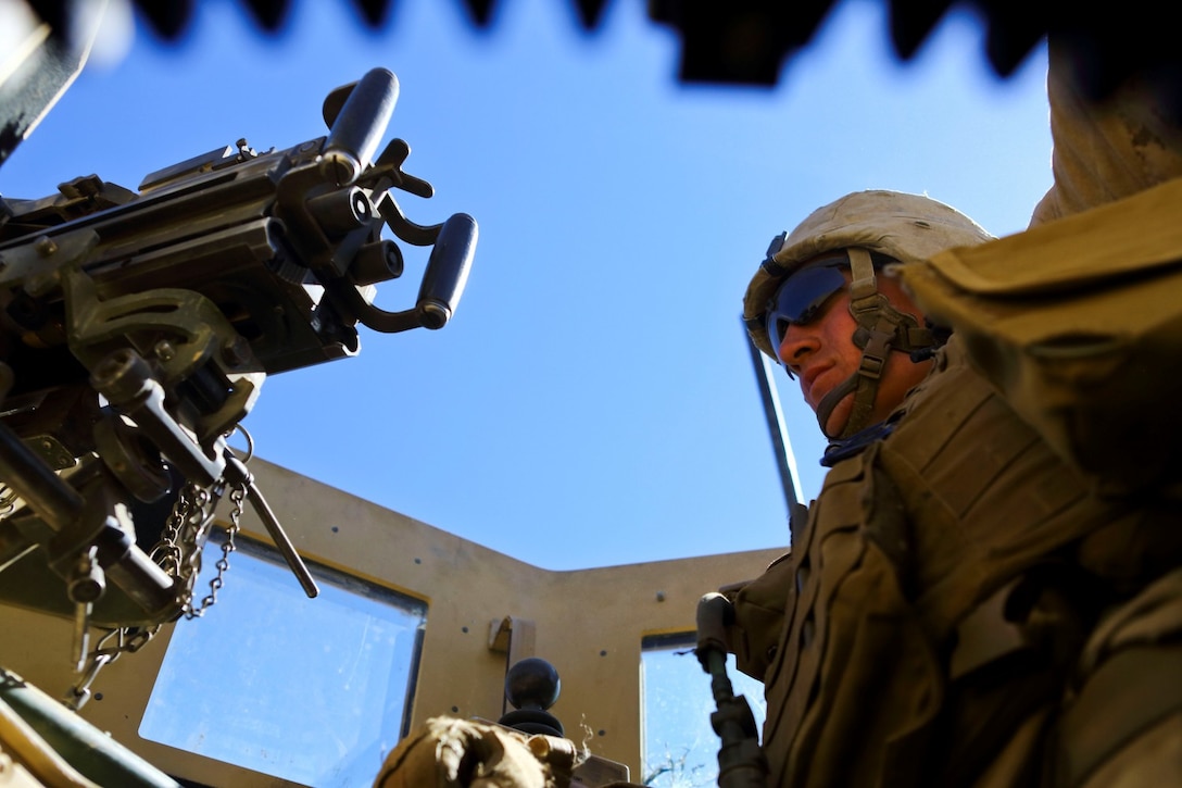 U.S. Marine Corps Lance Cpl. Michael Burchfield, a rifleman with India Co., 3rd Battalion, 7th Marine Regiment provides  security from the turret of a Mine Resistant Ambush Protected vehicle in Now Zad district, Helmand province, Afghanistan, Feb. 17, 2014. The Marines supported Afghan  forces who were conducting an operation in the area. (U.S. Marine Corps photo by Cpl. Sean Searfus/ Released)
