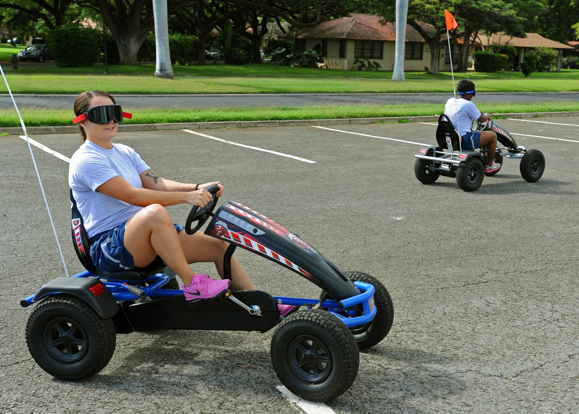 Airmen from the 15th Medical Group struggle to drive as they take part in a driving simulation game while wearing goggles that replicate the effects of alcohol during the group’s Wingman Day at Joint Base Pearl Harbor-Hickam, Hawaii, Feb. 20, 2014. The event highlighted the dangers of drinking and driving and the consequences associated with it. (U.S. Air Force photo/Master Sgt. Jerome S. Tayborn)
