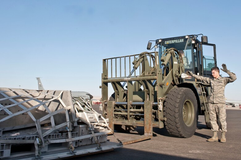 U.S. Air Force Senior Airman Staci Cahill, 99th Logistics Readiness Squadron transportation journeyman, moves cargo with a 10K all terrain forklift while Senior Airman Zachary Schroeder, 99th LRS air transportation journeyman, directs her on the flightline Feb. 19, 2014, at Nellis Air Force Base, Nev. The 99th LRS air terminal staff is in charge of processing incoming and outgoing duty passengers and mobility cargo. Depending on the type of mission, air terminal staff receive and send passengers and cargo from everywhere around the world. (U.S. Air Force photo by Senior Airman Matthew Lancaster)