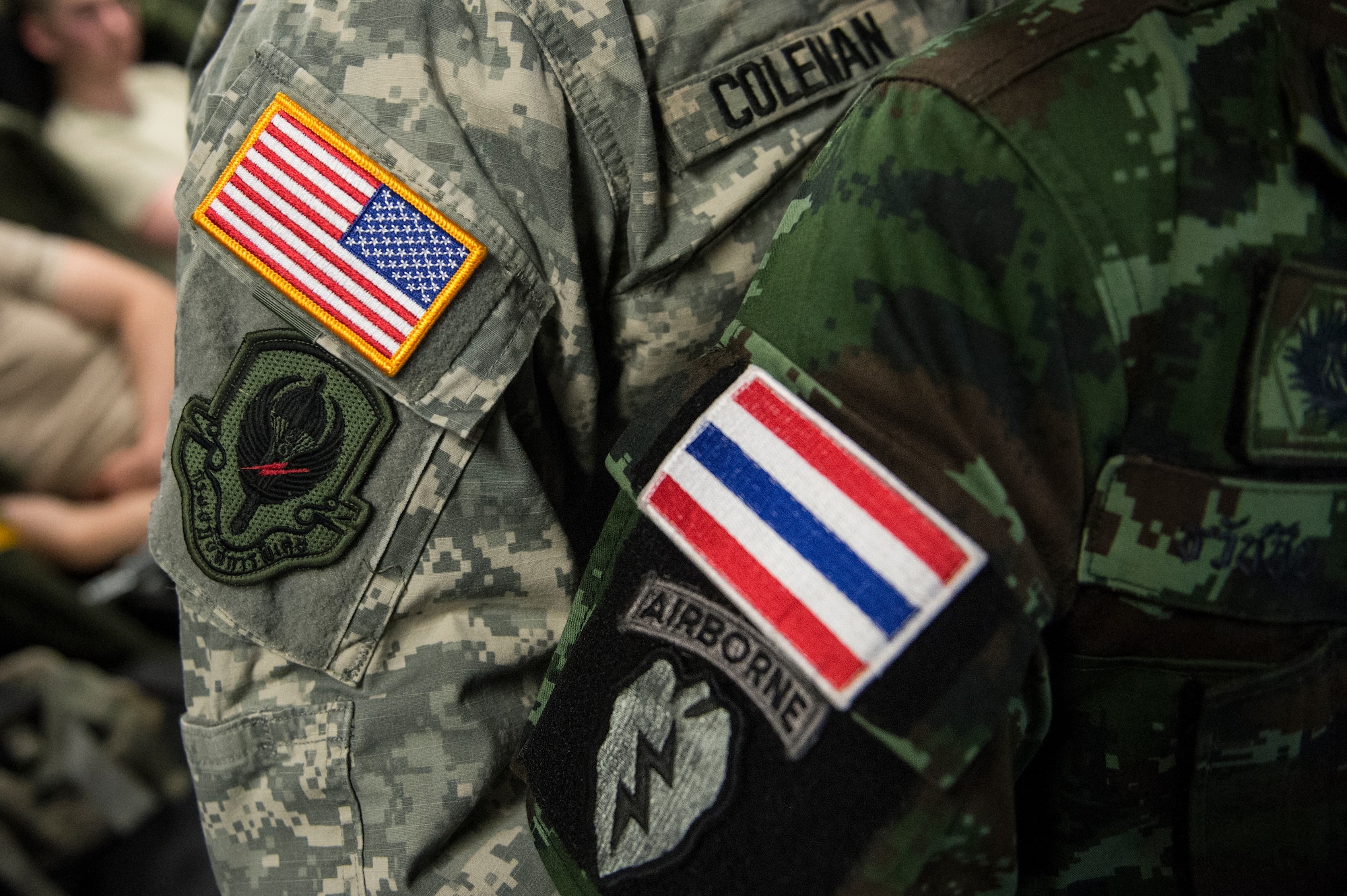 A U.S. Army Soldiers from the 4th Infantry Brigade Combat Team (Airborne), 25th Infantry Division and a Royal Thailand Army soldier show off their traded patches prior to an airborne forced entry operation into Lop Buri, Thailand for Operation Cobra Gold 2014, Jan.14, 2014. CG14, in its 33rd iteration, demonstrates the U.S. and the Kingdom of Thailand's commitment to their long-standing alliance and regional partnership, prosperity and security in the Asia-Pacific region. (U.S. Air Force photo by Senior Airman James Richardson)