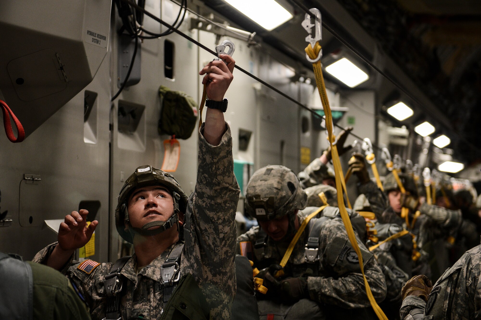 Paratroopers from the 4th Infantry Brigade Combat Team (Airborne), 25th Infantry Division attach their static line hooks to the static cable aboard a C-17 Globemaster III, Feb. 15, 2014, in preparation for a jump into Lop Buri, Thailand, in support of Exercise Cobra Gold 2014. CG14, in its 33rd iteration, demonstrates the U.S. and the Kingdom of Thailand's commitment to their long-standing alliance and regional partnership, prosperity and security in the Asia-Pacific region. (U.S. Air Force photo/Tech. Sgt. Sean Tobin)