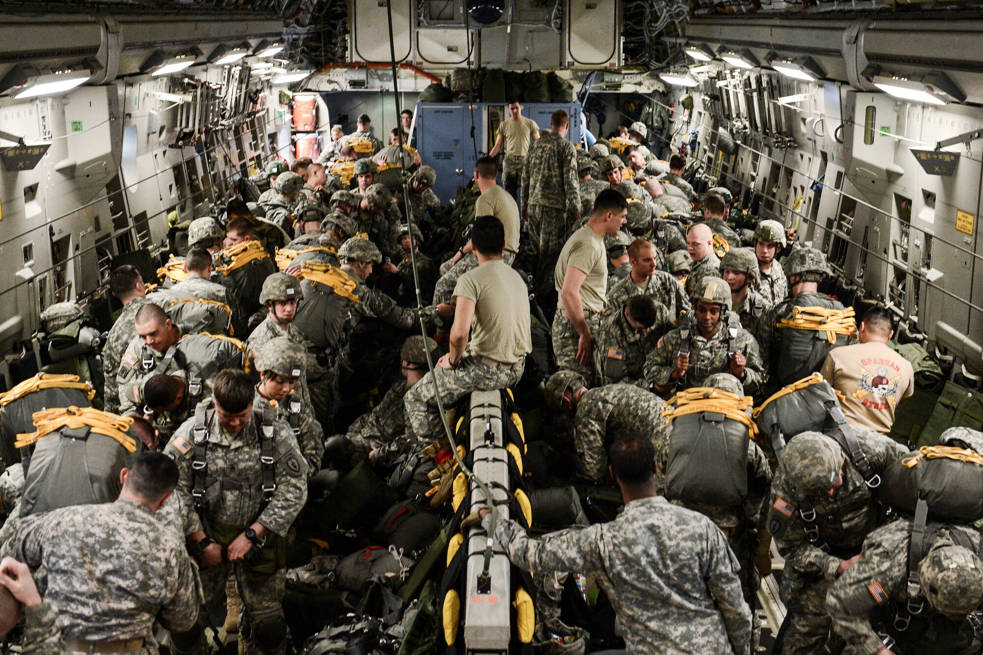 U.S. and Royal Thai armed forces don parachutes in preparation for a static line jump from a C-17 Globemaster III, Feb. 15, 2014, over Lop Buri, Thailand. The jump, a demonstration of forcible entry capabilities of U.S. and Royal Thai forces, was in support of Exercise Cobra Gold 2014, a multi-national exercise. (U.S. Air Force photo/Tech. Sgt. Sean Tobin)